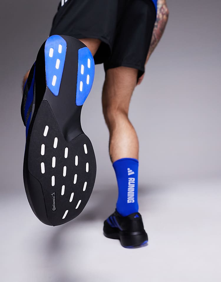 Close-up of sole on adidas Adizero Evo SL sneakers worn by man in blue running socks and black shorts