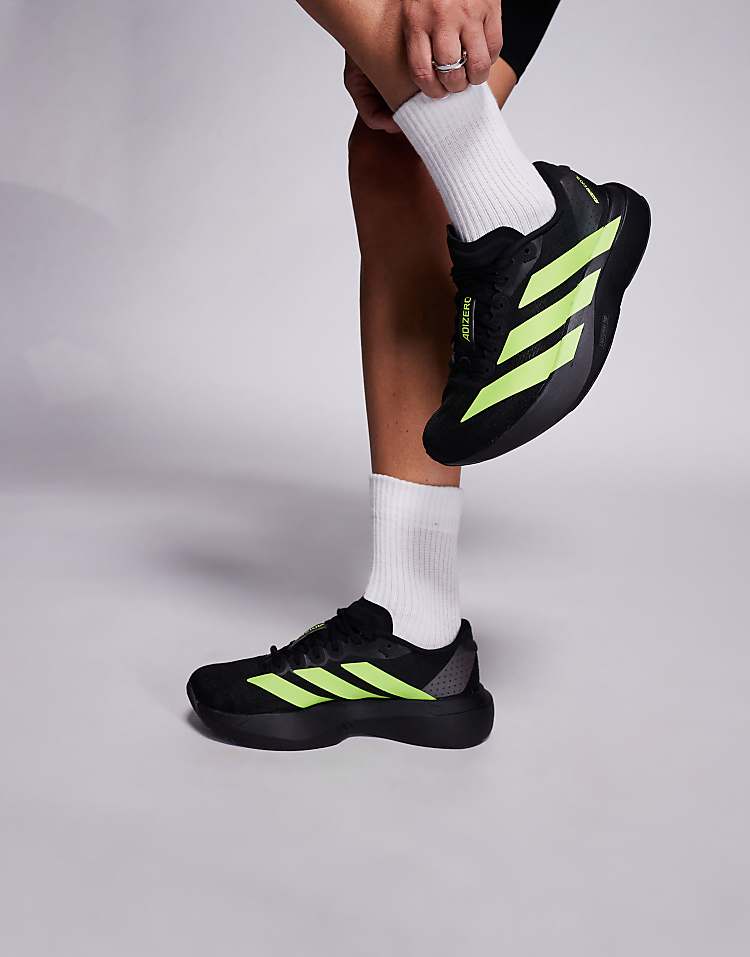 Men wearing black and neon green adidas Adizero Evo SL sneakers while adjusting white socks