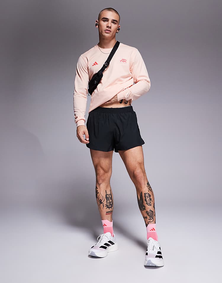 Man wearing adidas Adizero Evo SL sneakers with black shorts and pink long sleeve shirt from Modan Online