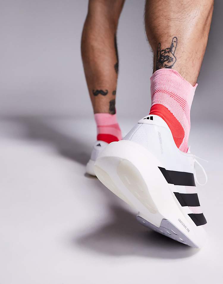 Close-up of adidas Adizero Evo SL sneakers in white with black stripes worn by a man with pink socks