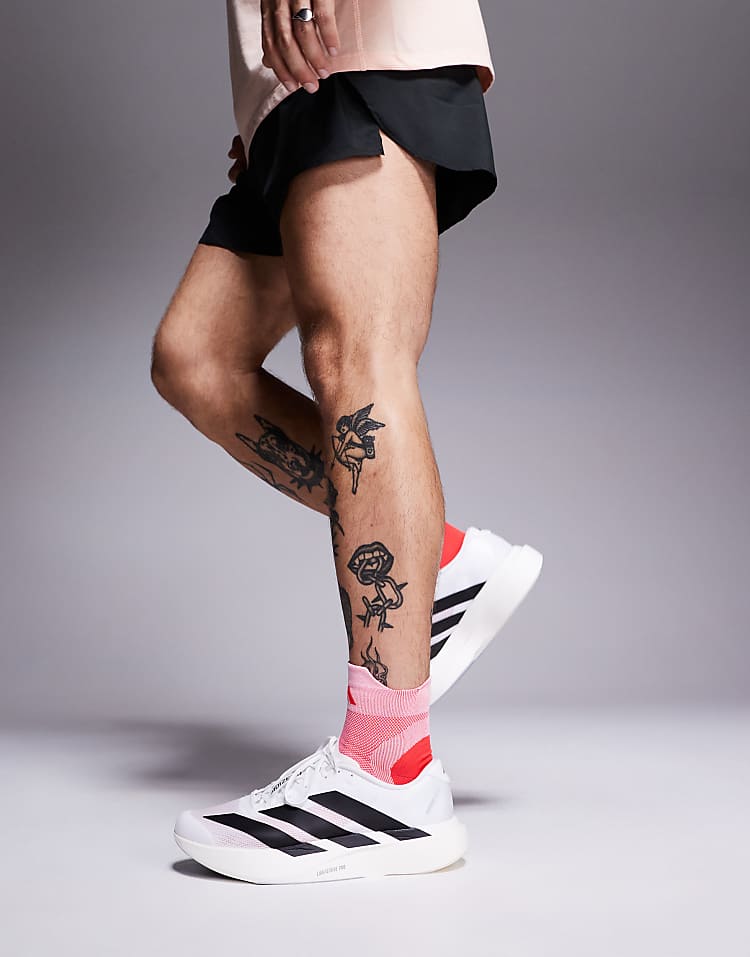 Men wearing adidas Adizero Evo SL sneakers in white with black stripes and pink socks