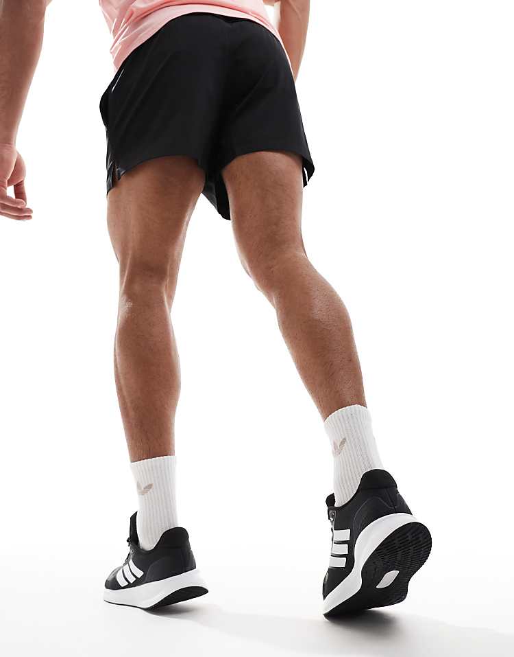 Men wearing adidas RunFalcon running shoes in black and white with white socks and black shorts