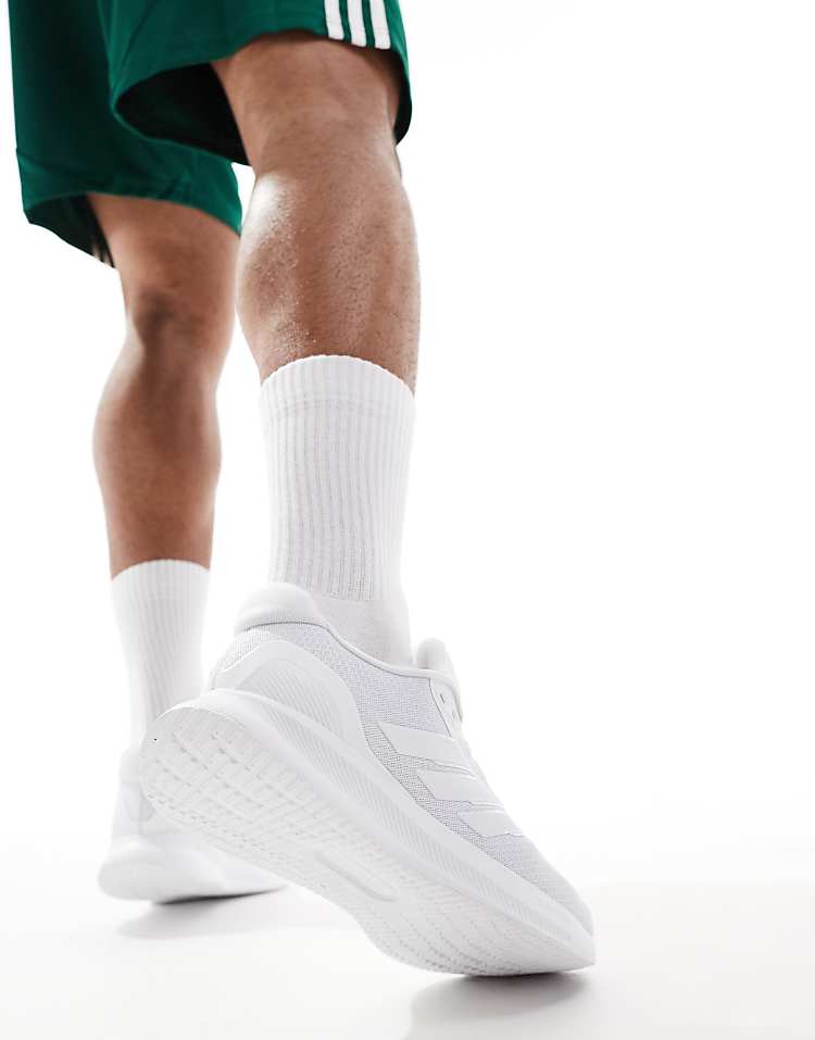 Heren wearing white adidas RunFalcon running shoes with white socks and green shorts