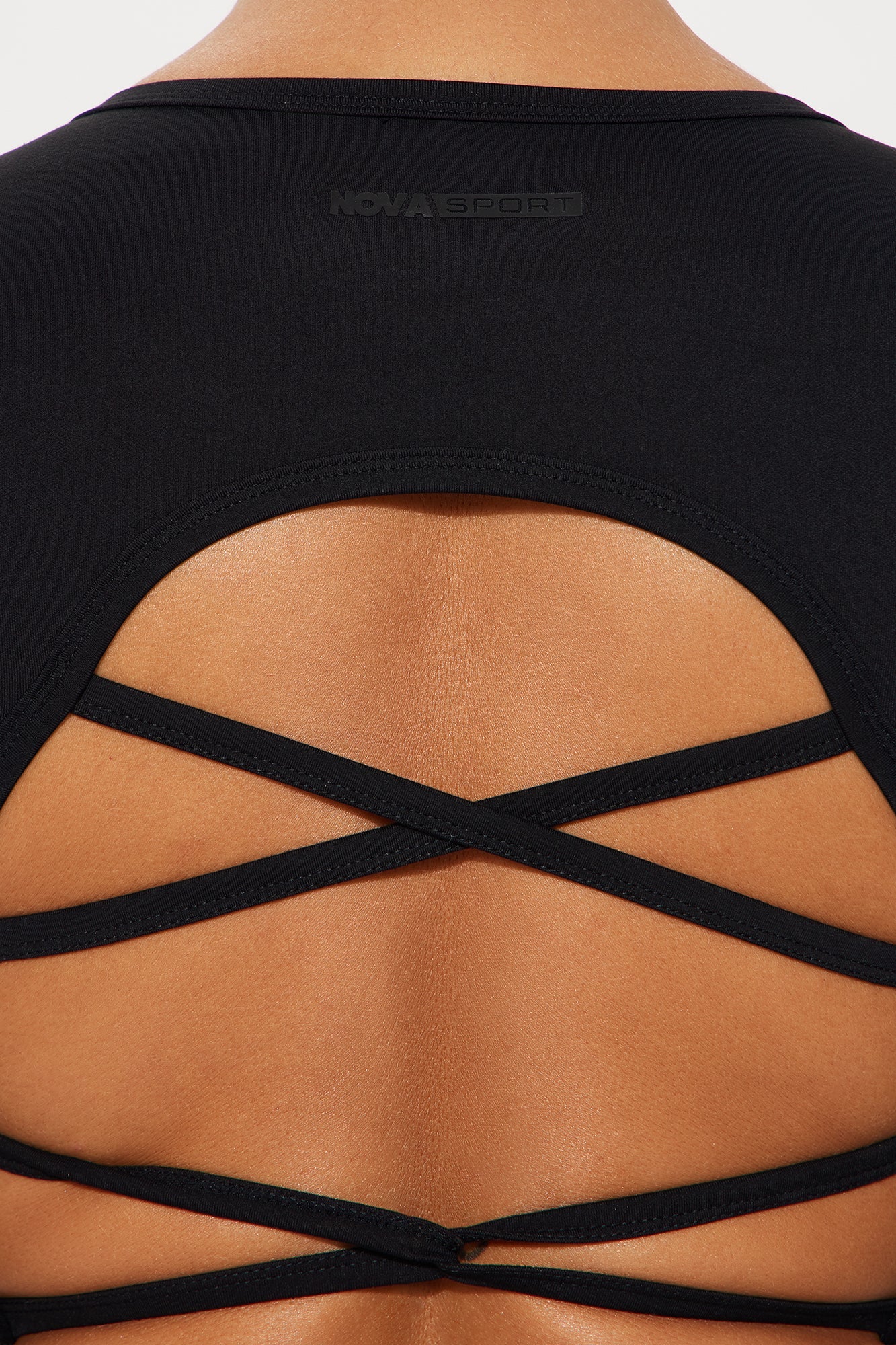 Back view of black active crop top by Nova Sport from Fashion Nova featuring crisscross strap design