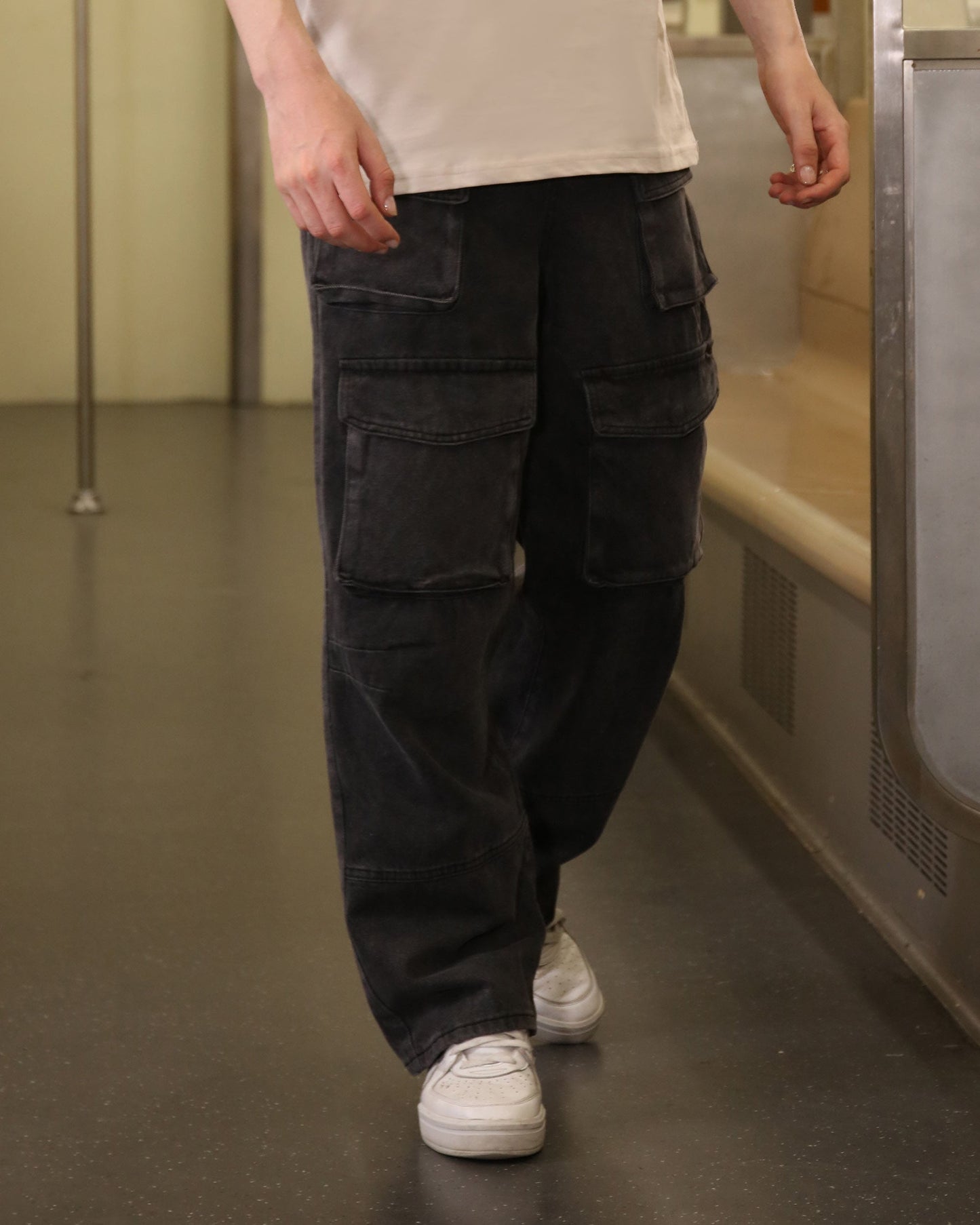 Logeqi black baggy jeans with pockets worn by a person with white sneakers and beige top