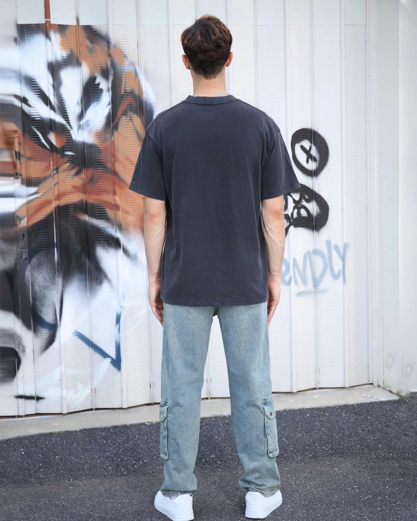 Back view of a Logeqi black crew neck t-shirt paired with light jeans for a casual look