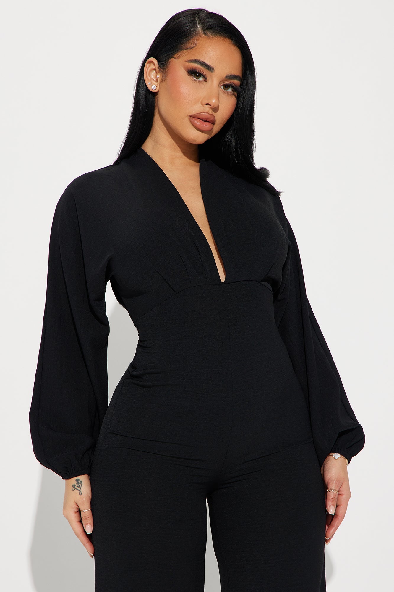 Fashion Nova black jumpsuit for women with a deep V-neck and elegant puff sleeves