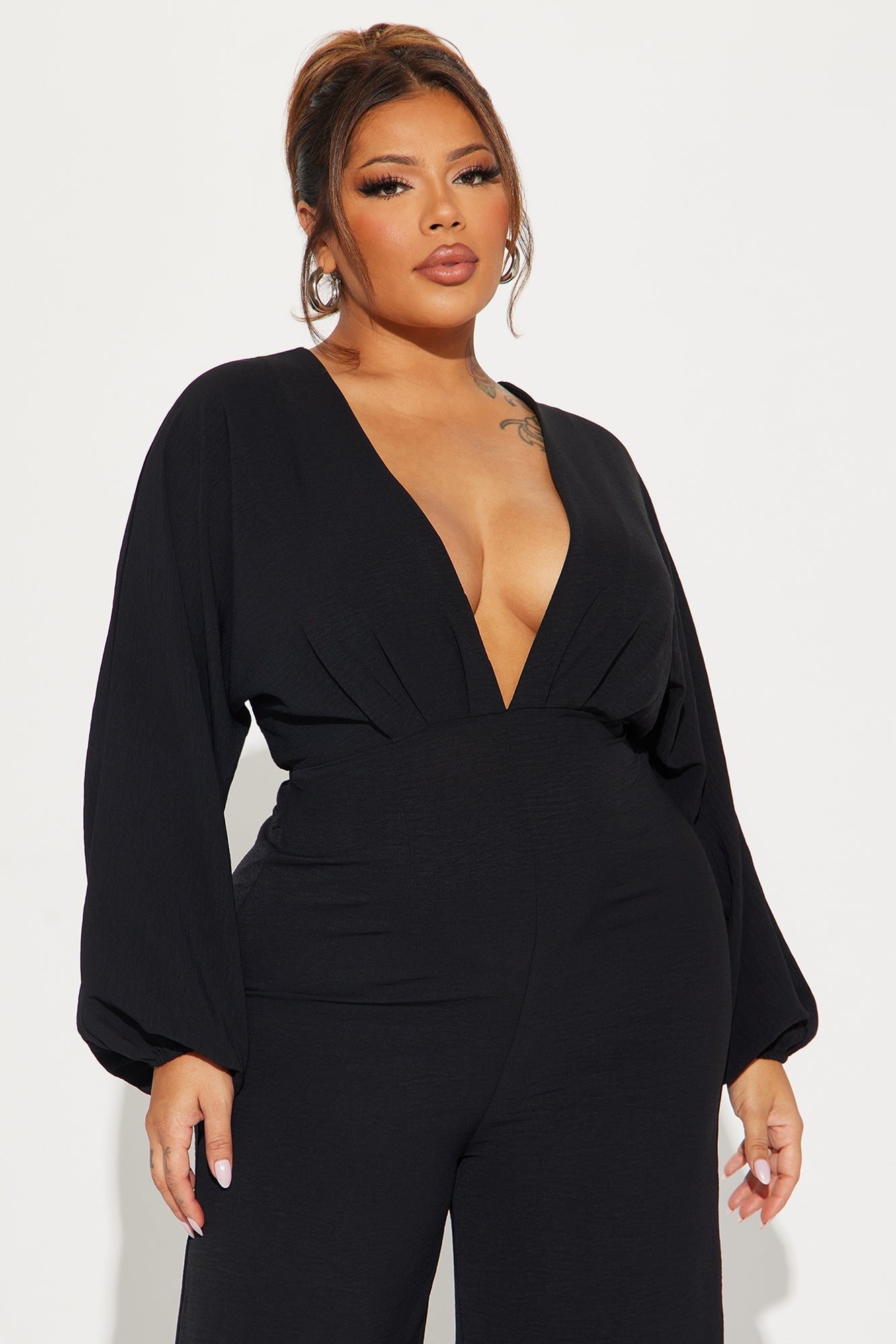 Fashion Nova black jumpsuit for women with deep V neckline and stylish long sleeves