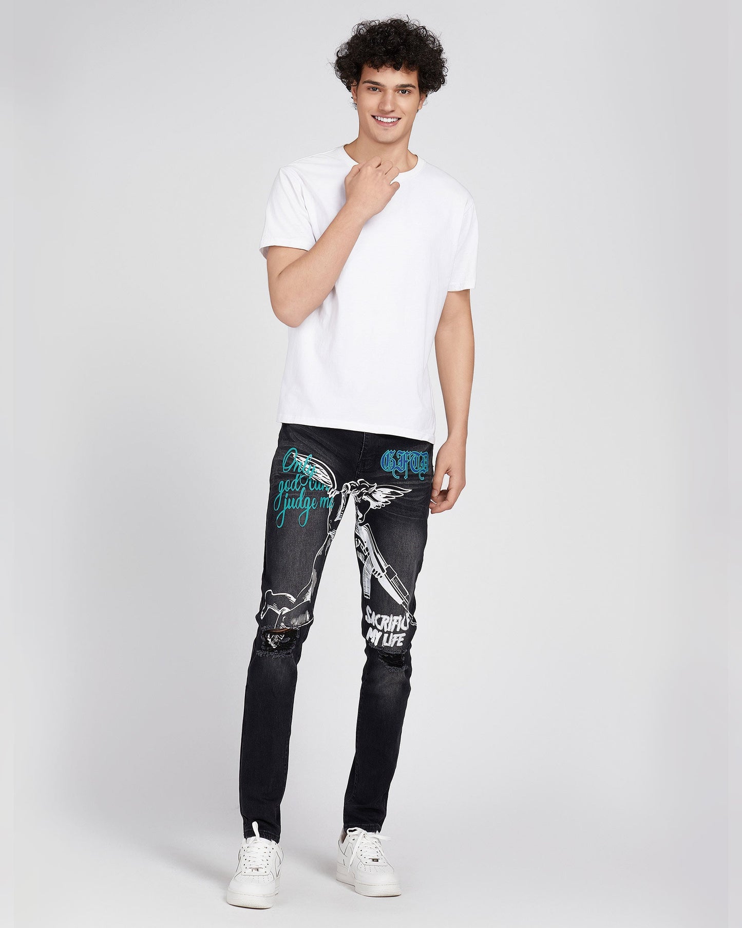 Logeqi black ripped graffiti jeans with white and blue graphic prints worn by male model