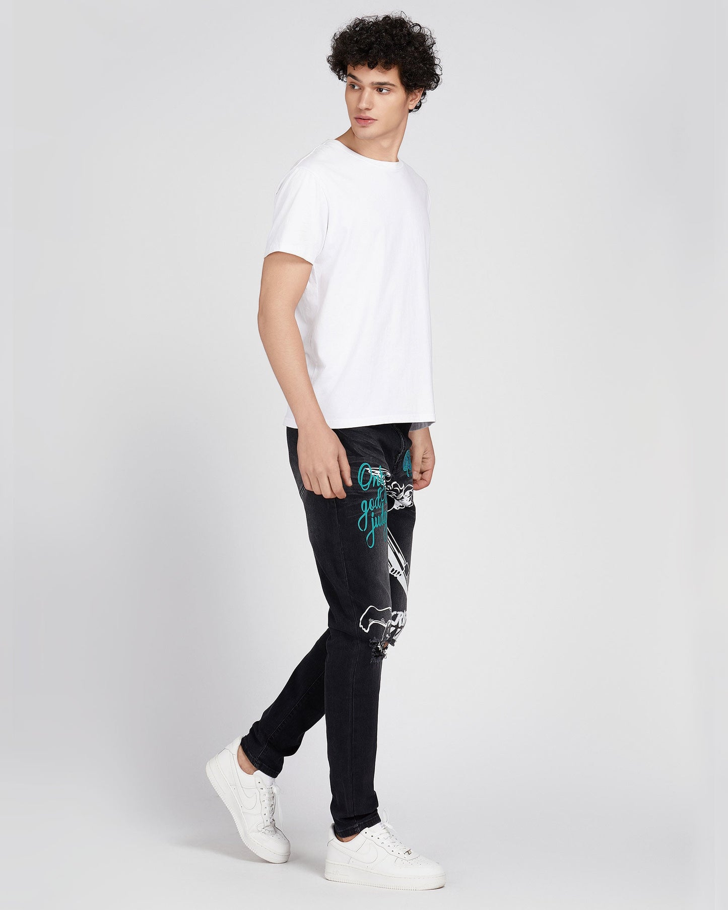 Logeqi black ripped graffiti jeans worn by male model with white sneakers and white t-shirt