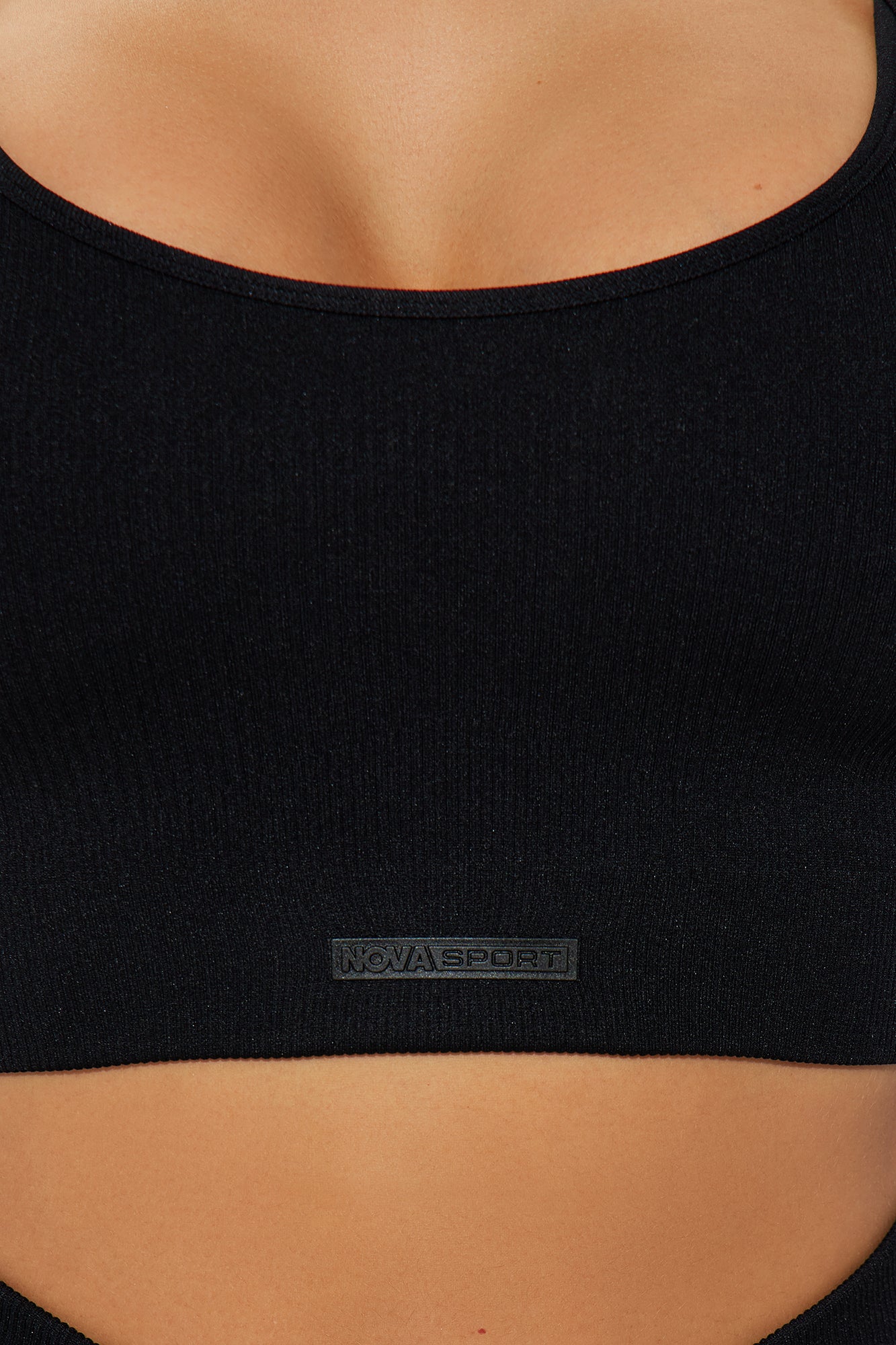 Close-up of the Nova Sport logo on a black seamless 2 piece activewear set for stylish workouts
