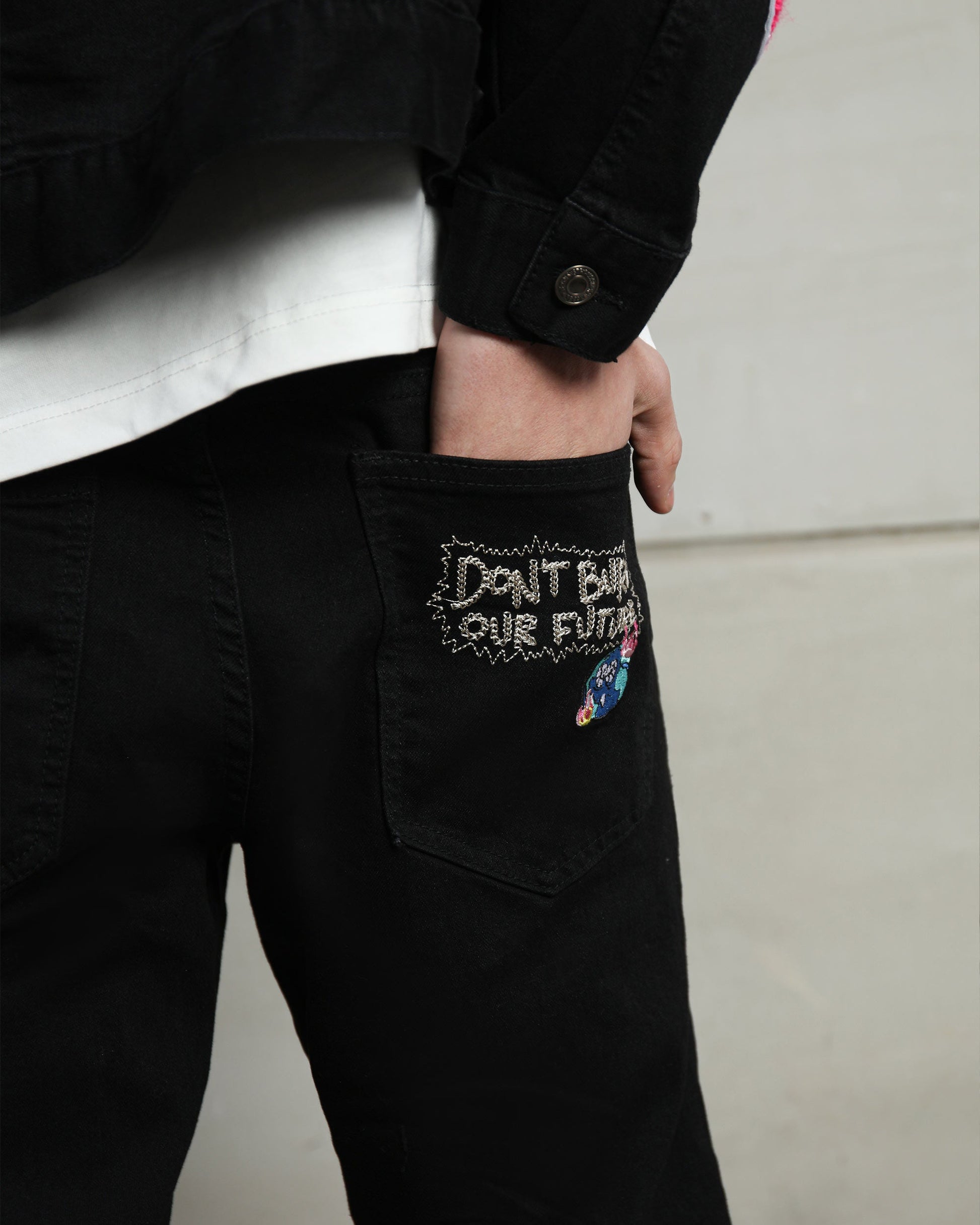 Close-up of Logeqi black streetwear patchwork jeans featuring unique rear pocket embroidery