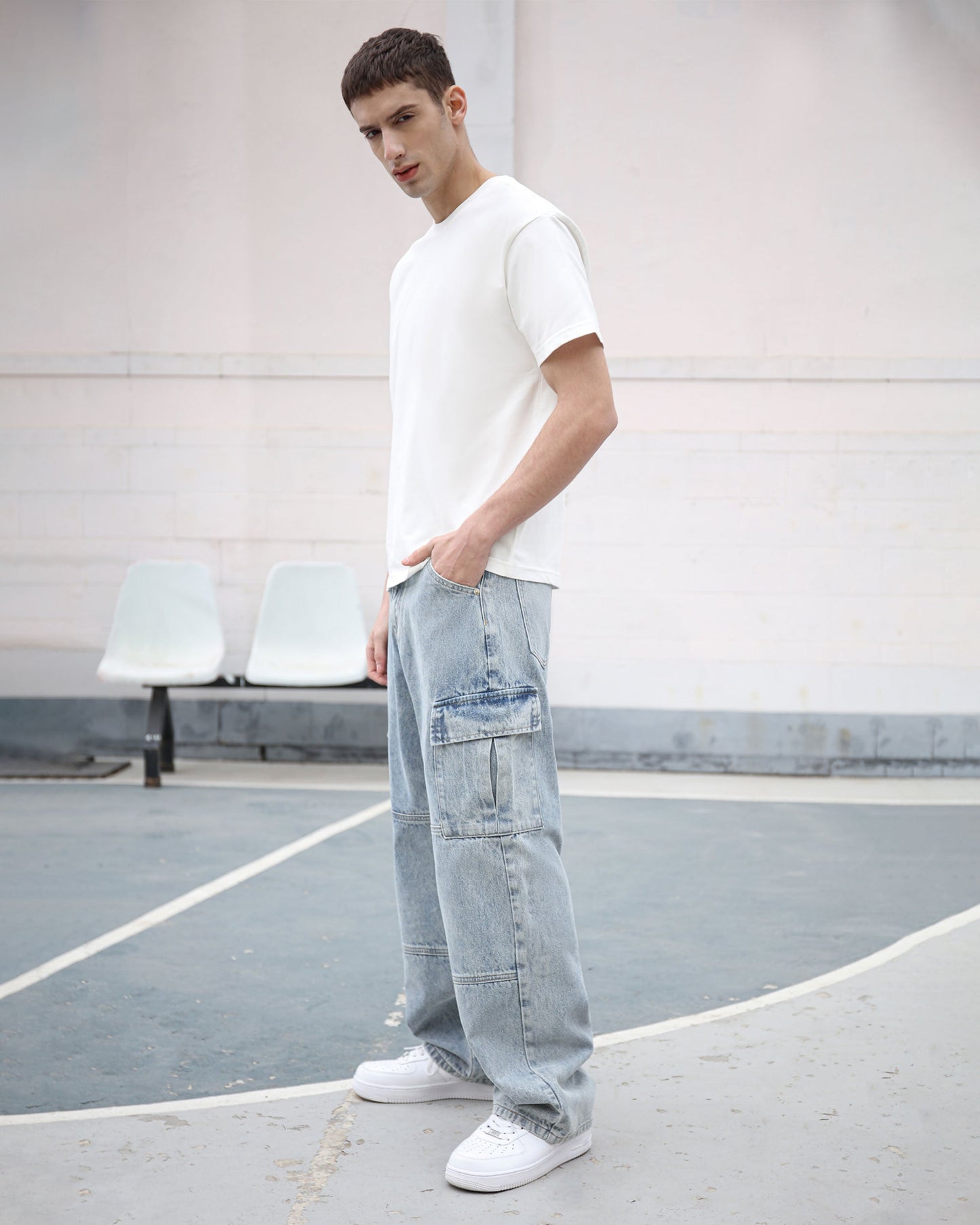 Logeqi blue cargo jeans for men with multiple pockets worn by a male model in white sneakers