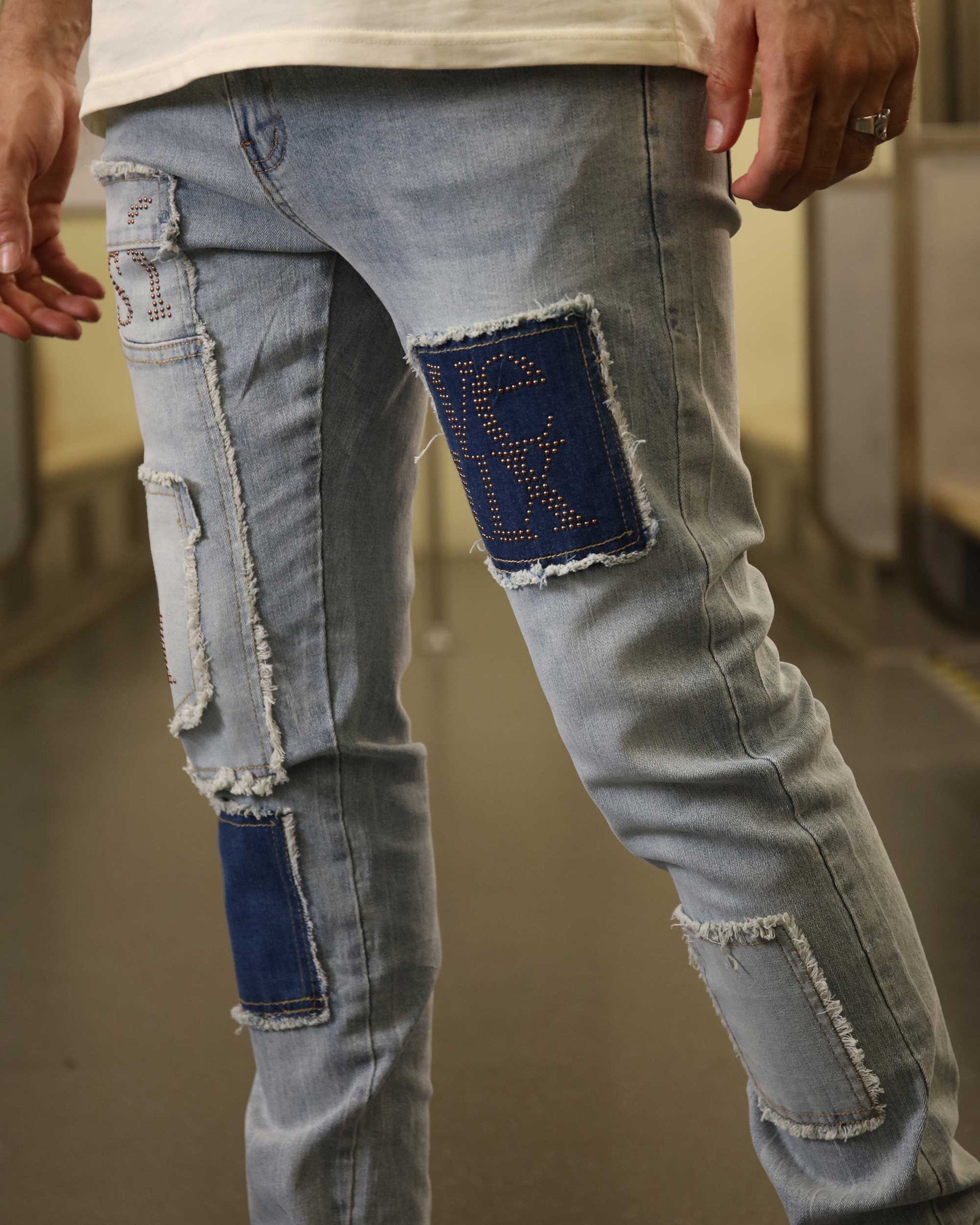 Logeqi blue jeans with diamond accents featuring distressed patches and rhinestone detailing on light wash denim