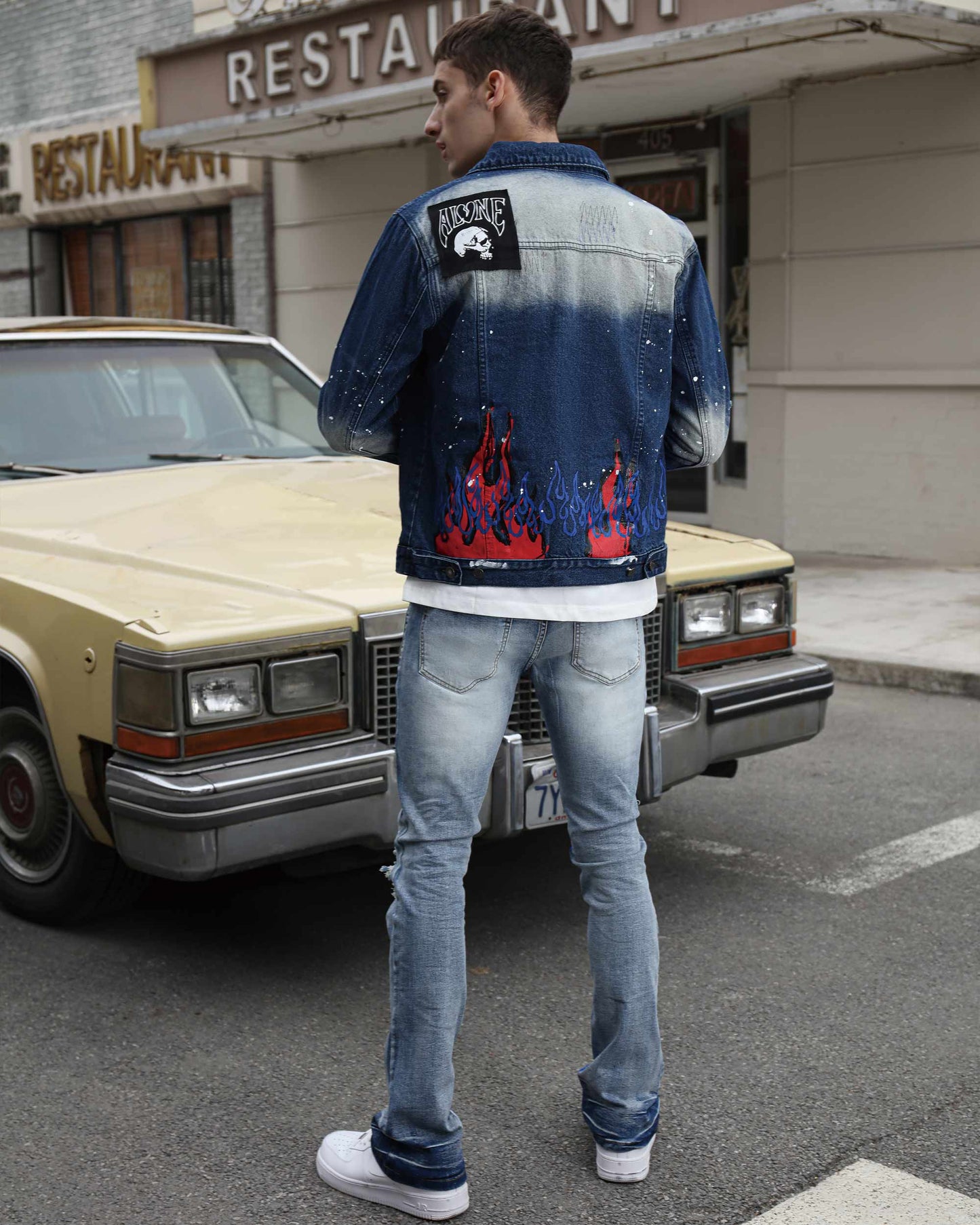 Man wearing blue retro flared jeans with a stylish jacket in an urban setting