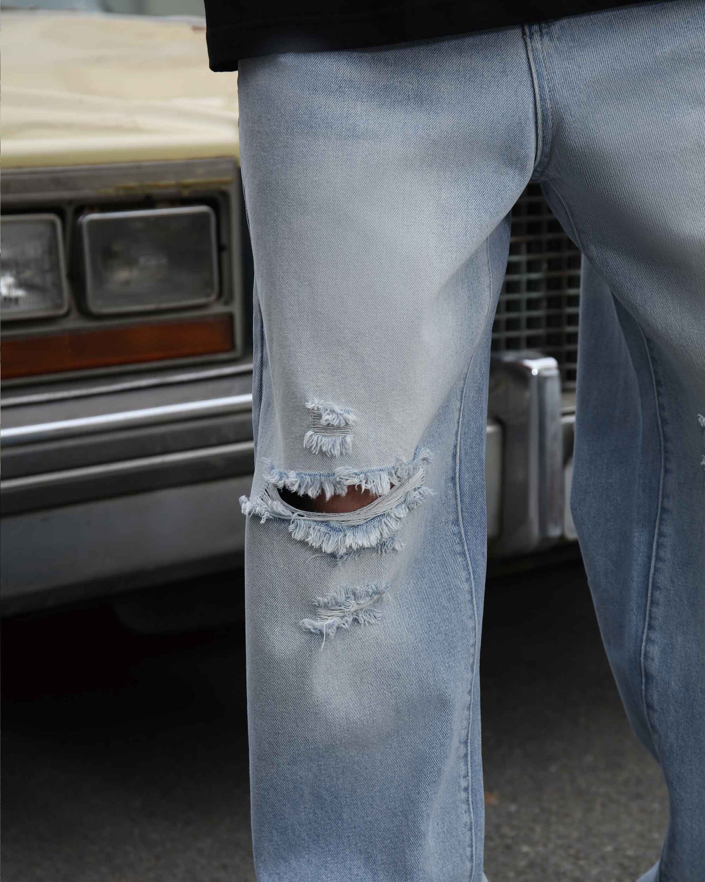 Logeqi blue ripped baggy jeans with distressed detailing on front knee area