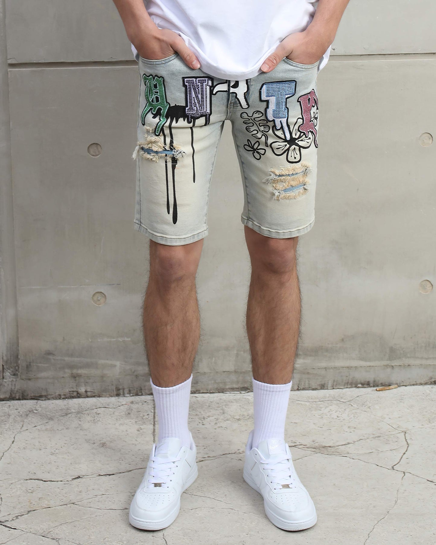 Logeqi distressed graffiti denim shorts with colorful letters and ripped details worn with white sneakers