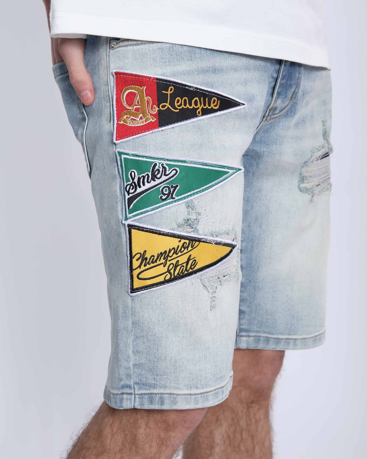 Logeqi light wash denim shorts with colorful patches and distressed details on model