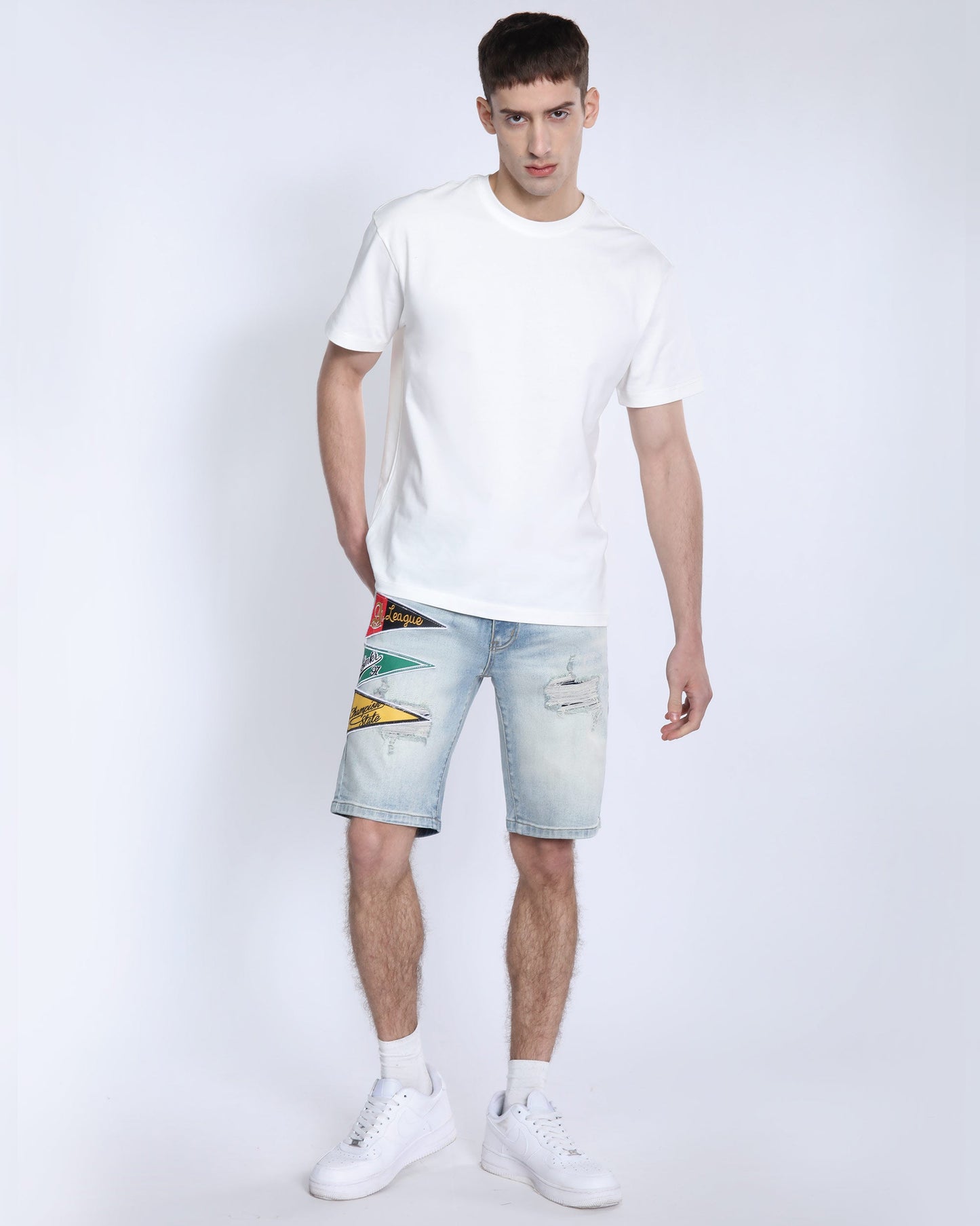 Men's light wash denim shorts by Logeqi with distressed details and colorful patches