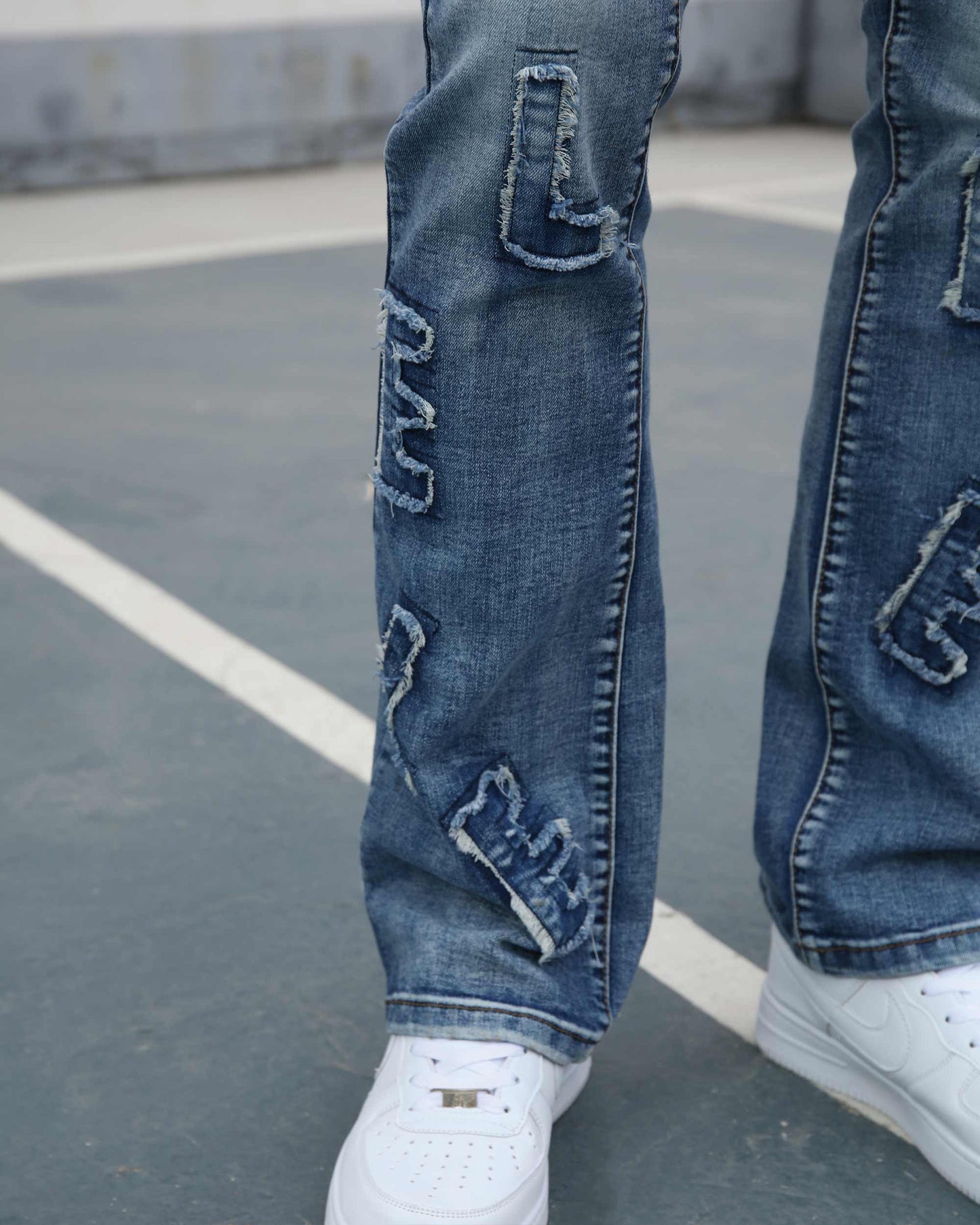 Logeqi medium wash ripped jeans with distressed detailing paired with white sneakers