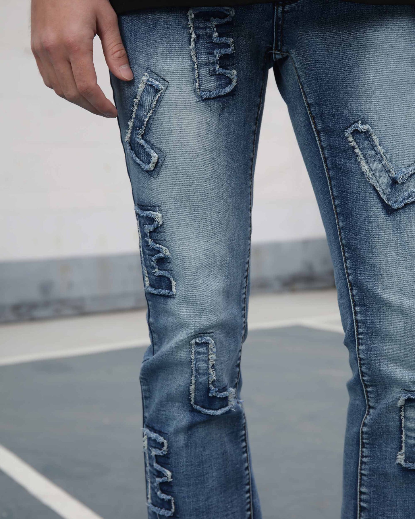 Logeqi medium wash ripped jeans with unique patch detailing on front legs