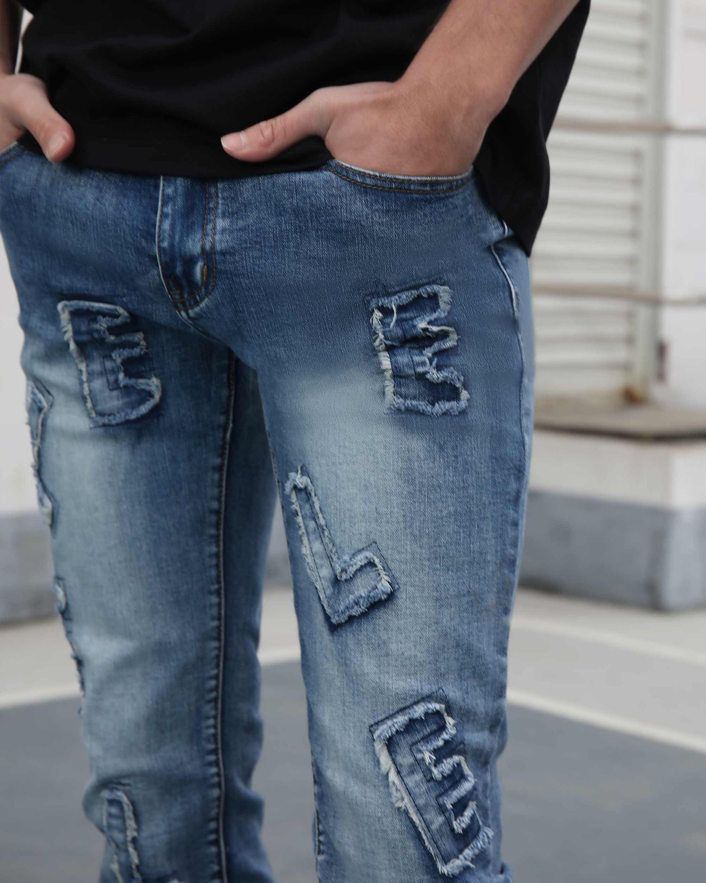 Logeqi medium wash ripped jeans with unique patch designs on front pockets and legs