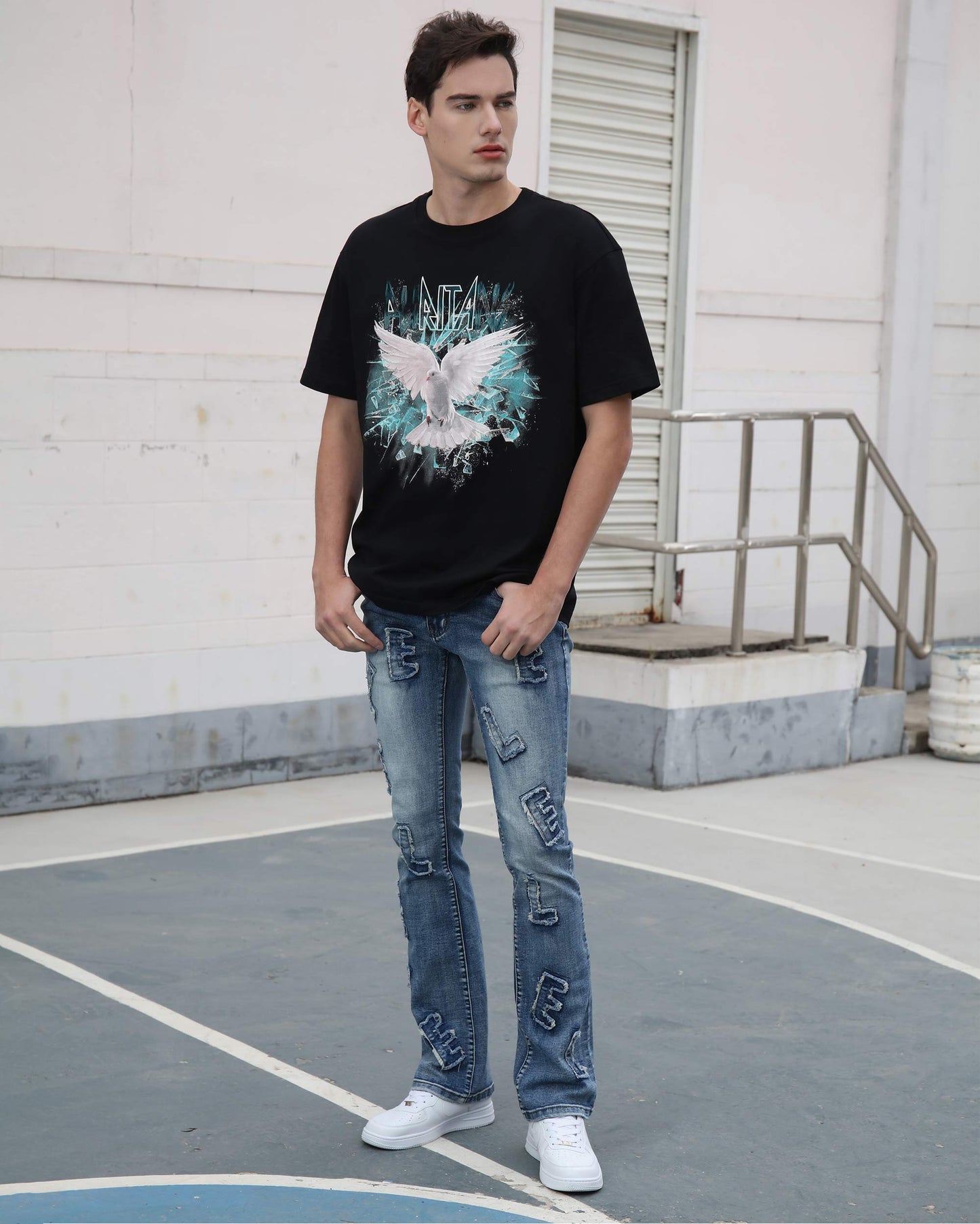 Man wearing Logeqi medium wash ripped jeans paired with a black graphic t-shirt and white sneakers