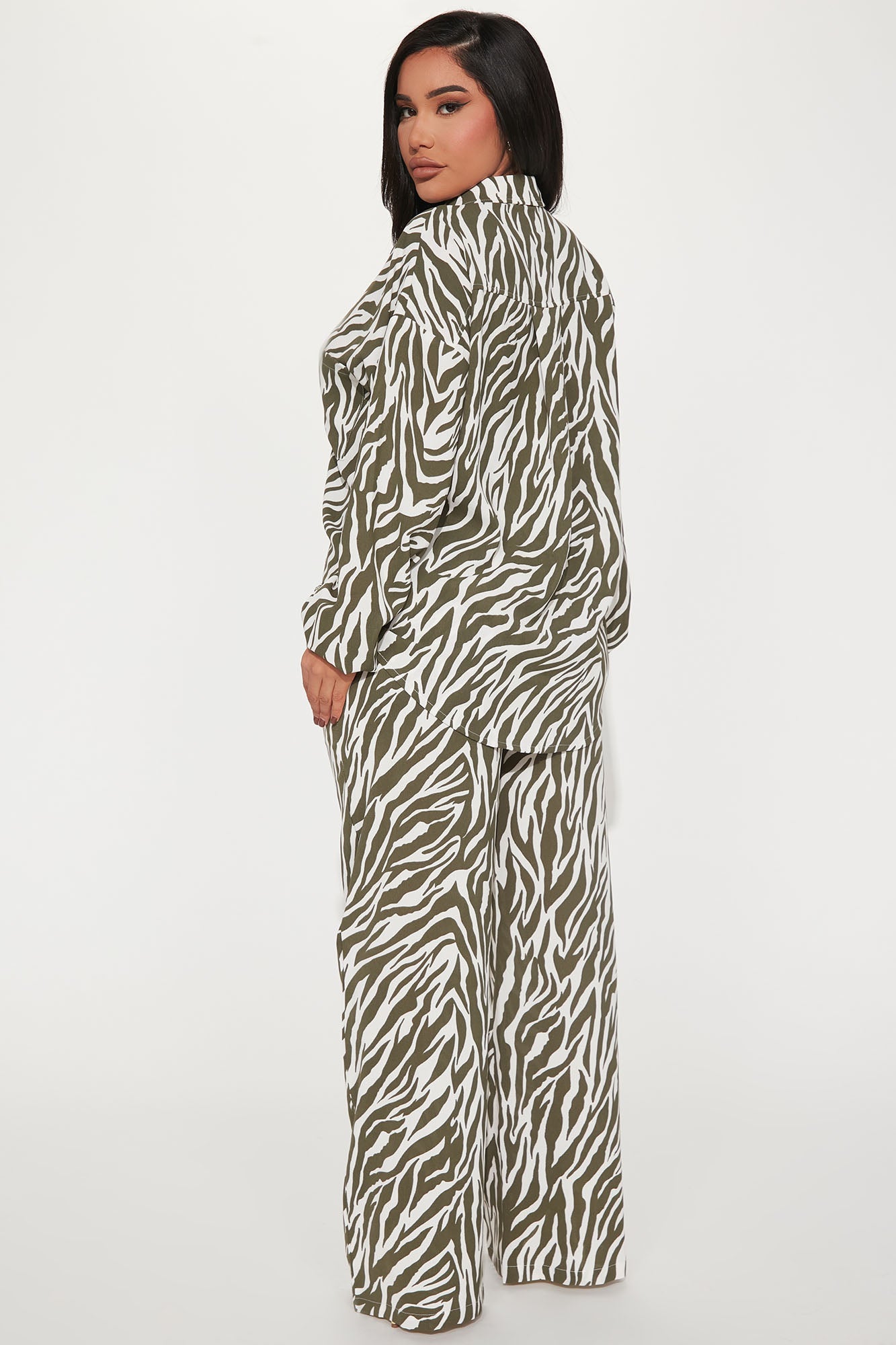 Fashion Nova model wearing olive zebra print pant set with button up long sleeve top and wide leg pants