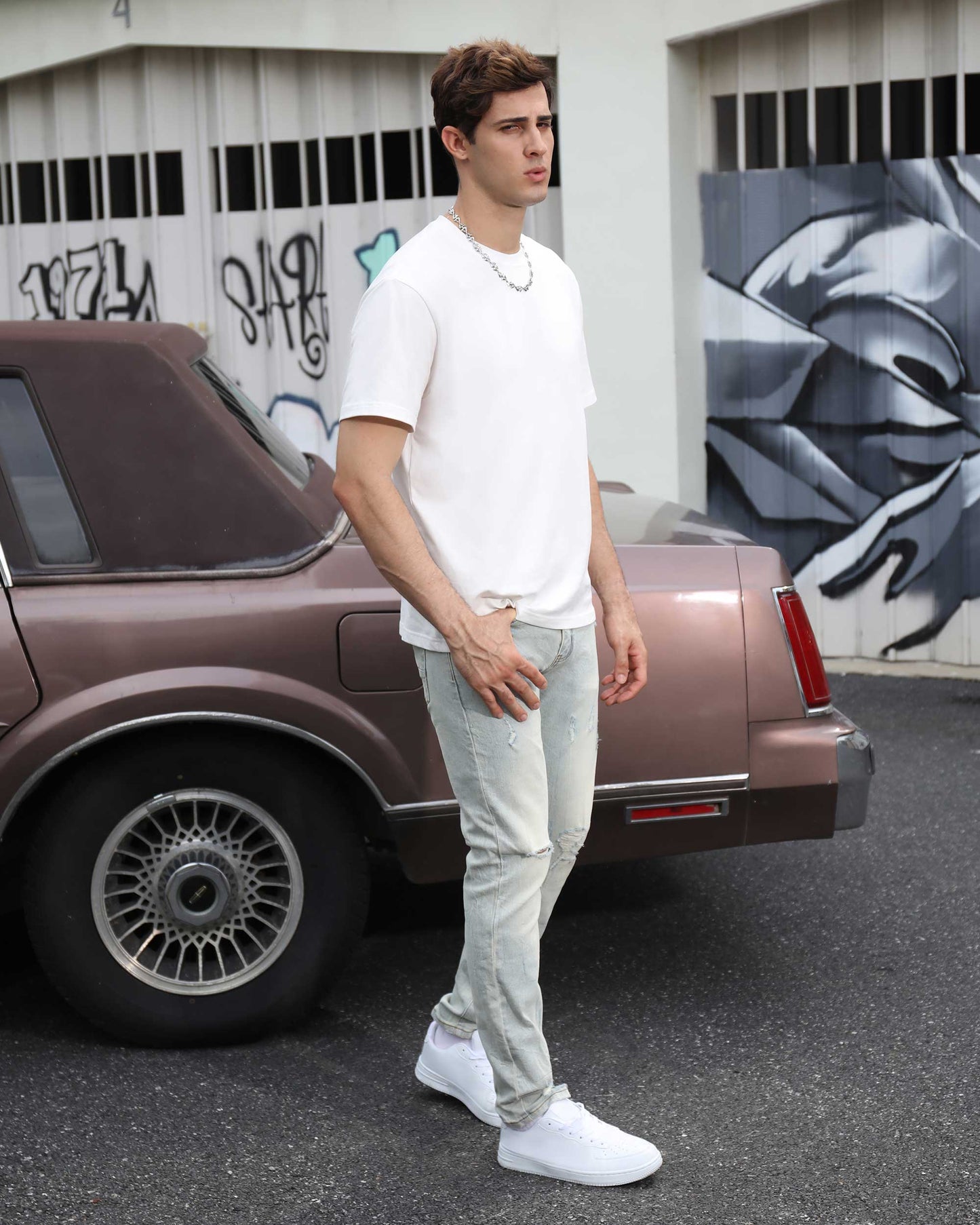 Logeqi straight fit ripped jeans in light wash, styled with a white t-shirt and sneakers outdoors