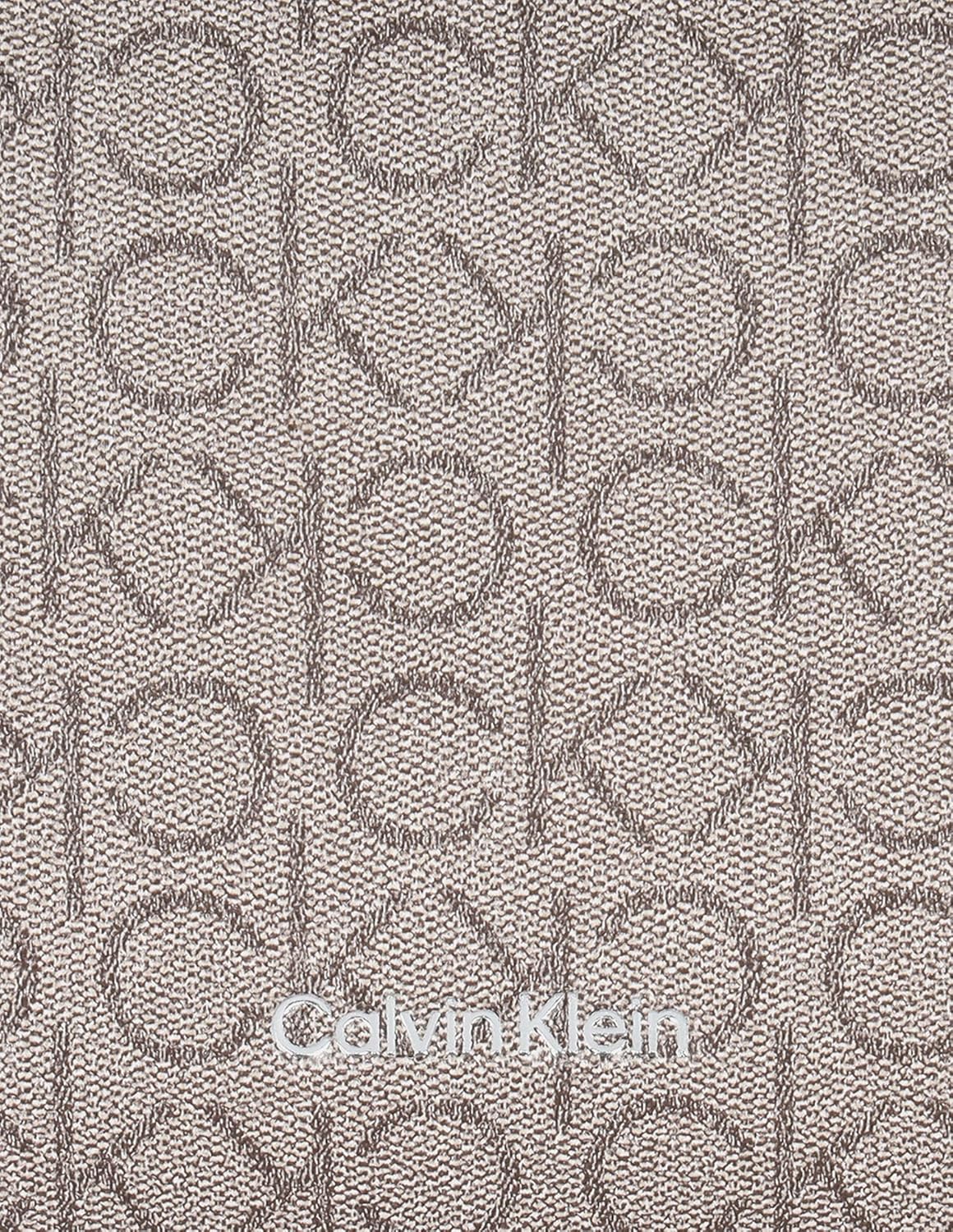 Close-up of the Calvin Klein Reyna crossbody bag featuring a textured logo pattern for stylish everyday use