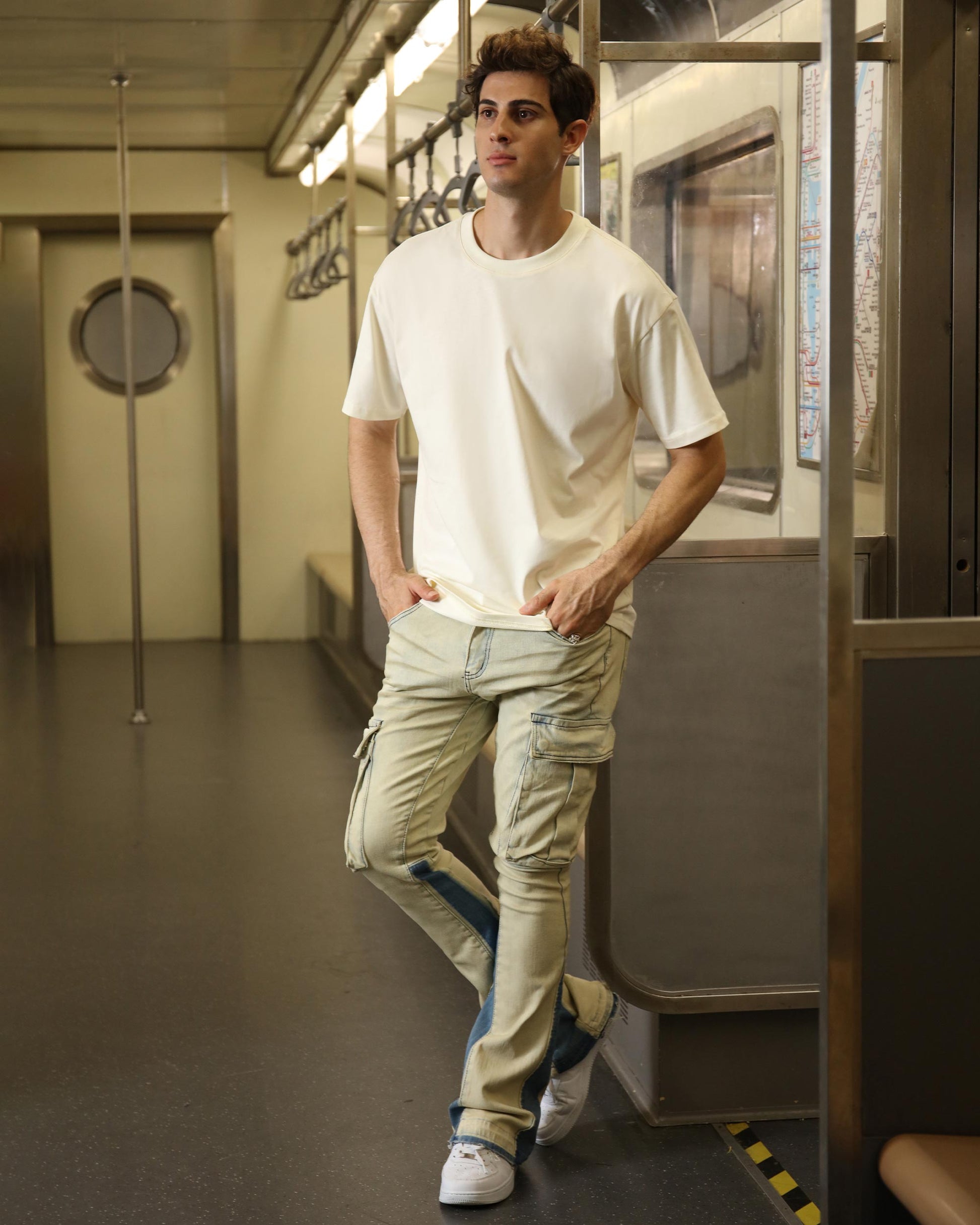Logeqi industrial style cargo jeans in light color, paired with a casual tee and sneakers in a subway setting
