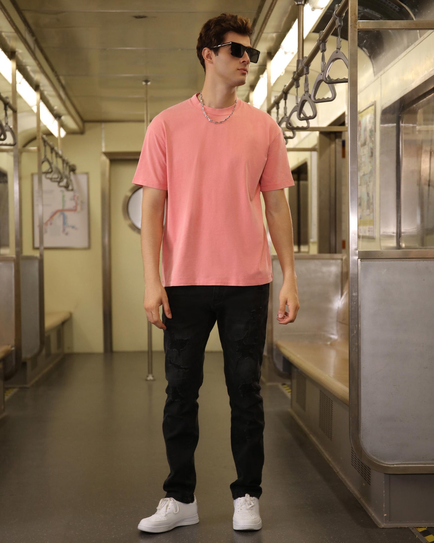 Logeqi classic pink t-shirt displayed on a model in a subway setting, paired with black pants