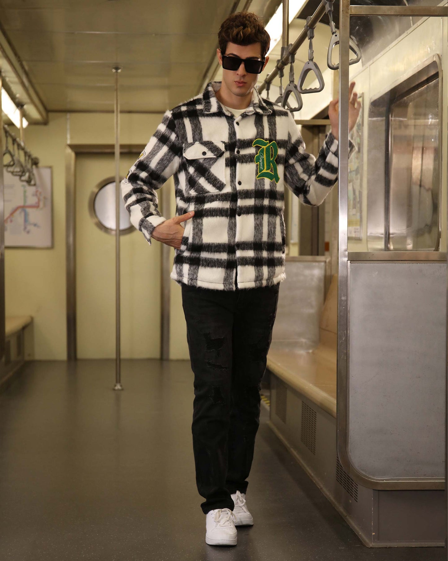 Man wearing Logeqi classic plaid moto jacket in black and white check pattern with green patch