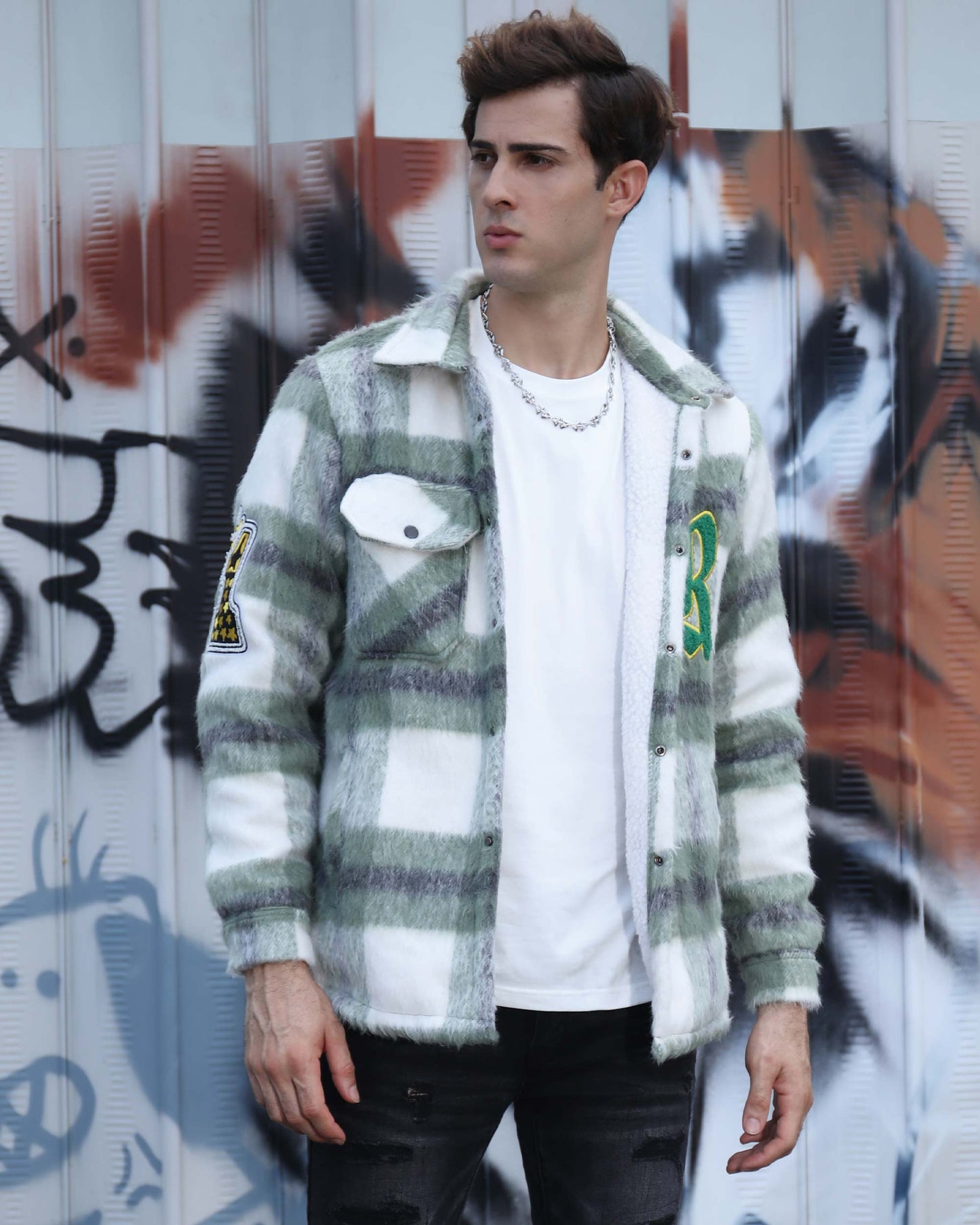 Logeqi classic plaid moto jacket in green and white worn by male model against graffiti wall