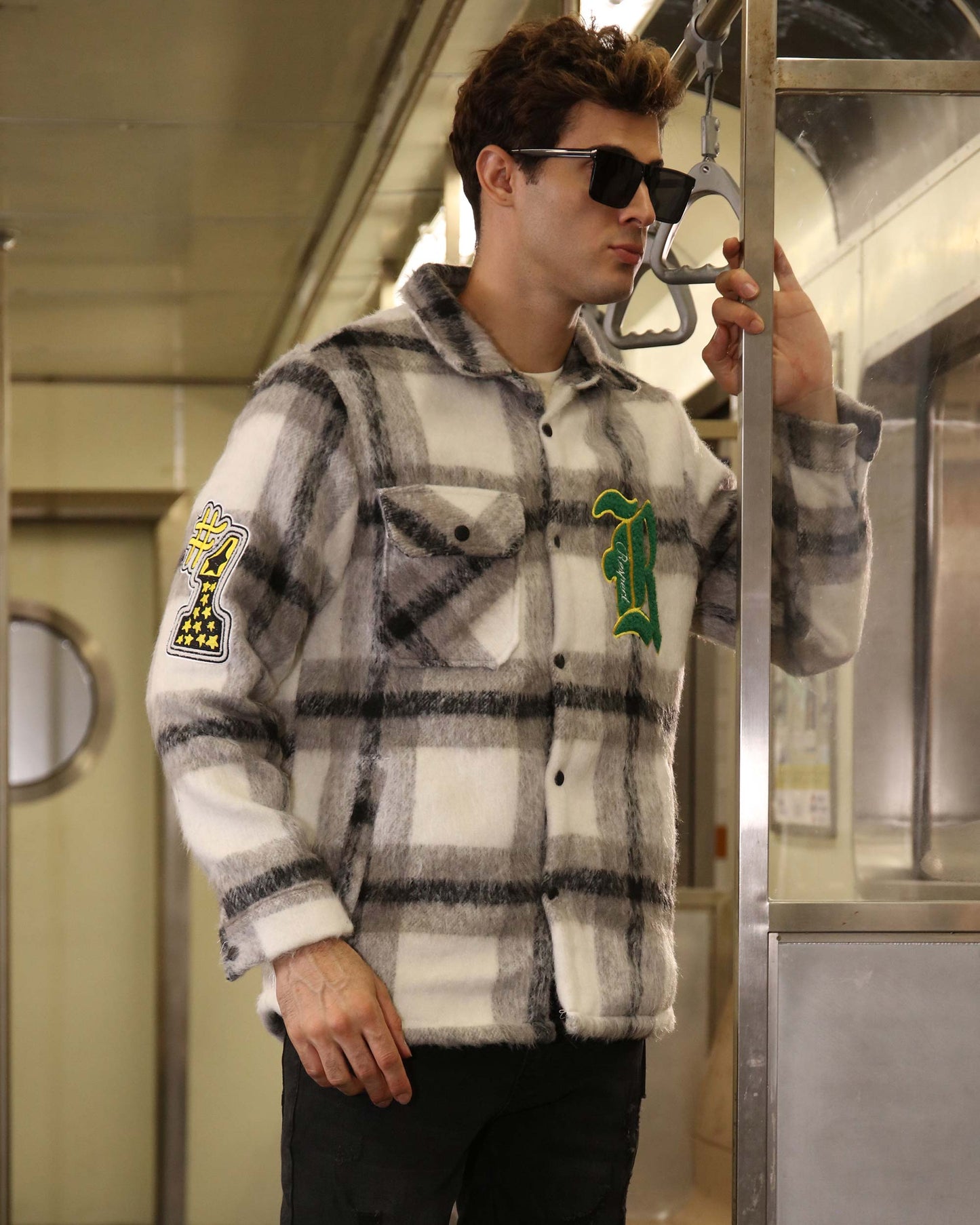 Logeqi classic plaid moto jacket in white and black worn by man in subway with patches on sleeves