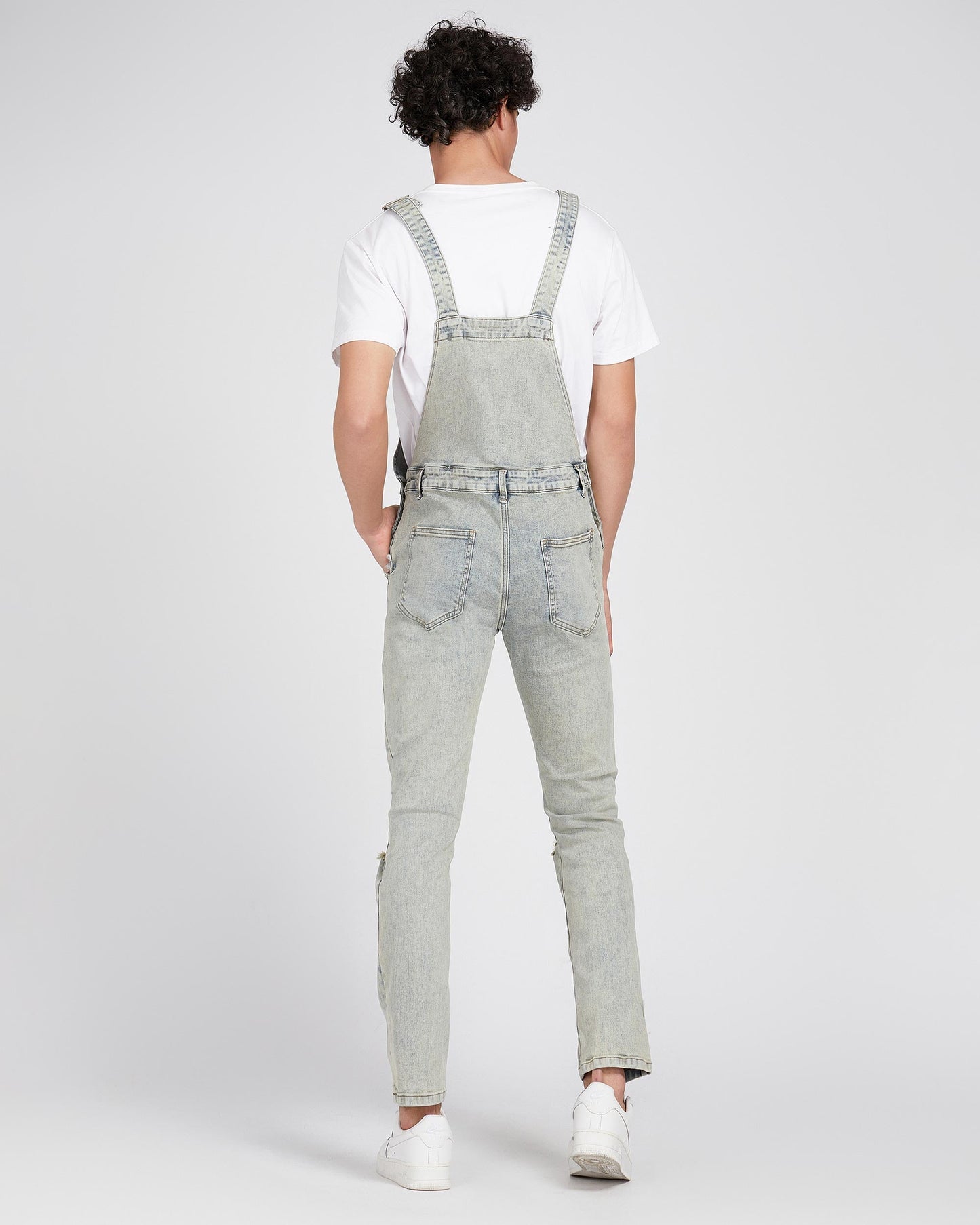 Logeqi classic ripped overalls jeans in light wash worn by a model from the back with adjustable straps