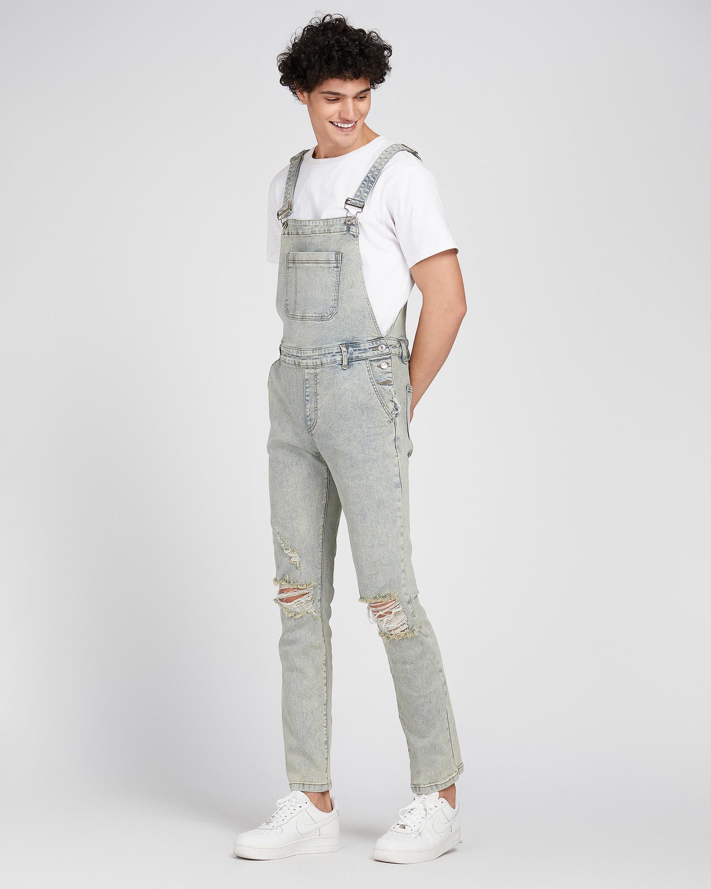 Logeqi classic ripped overalls in light wash denim worn with white t shirt and sneakers