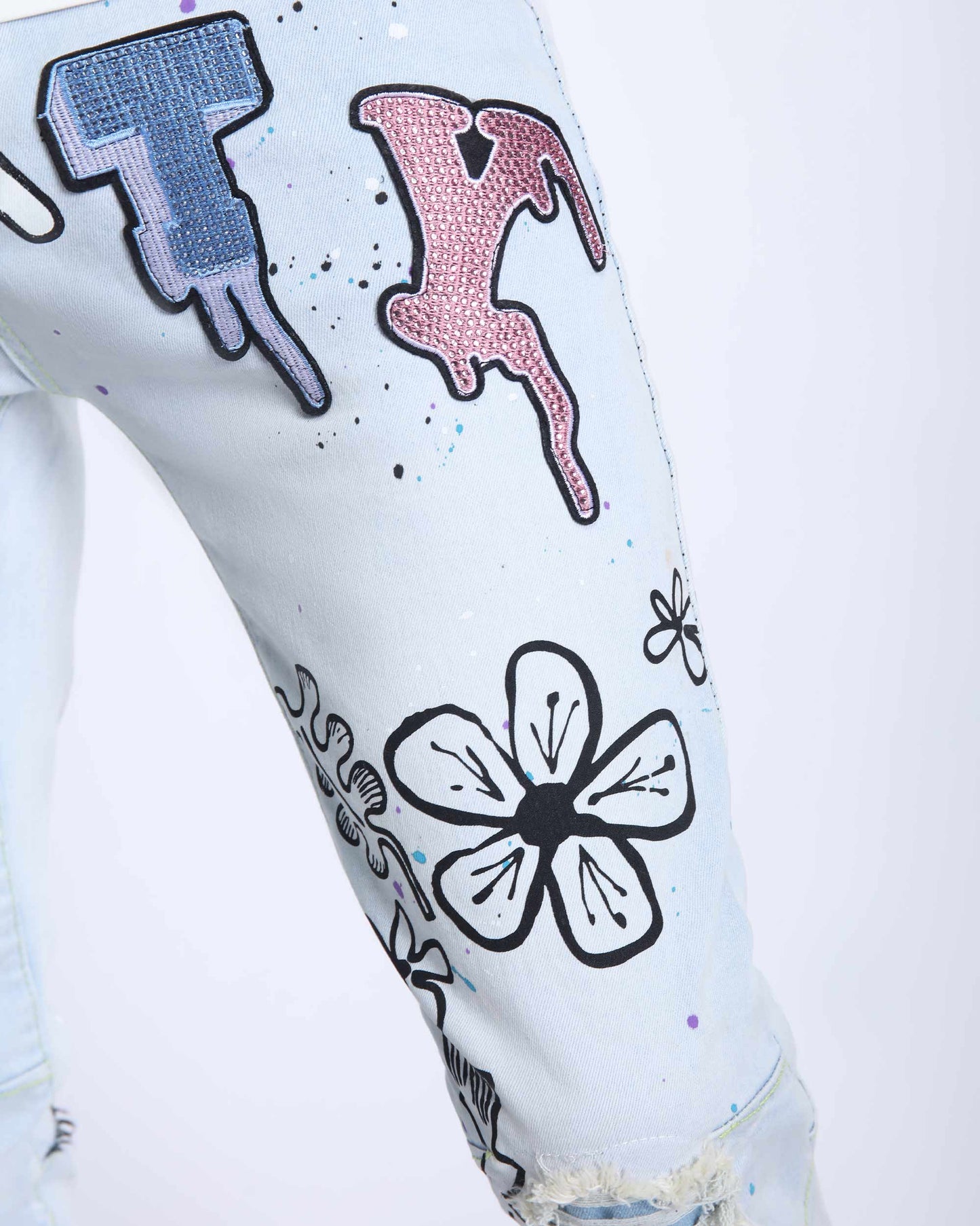 Logeqi white comic painted ripped jeans with colorful floral and graphic designs on leg