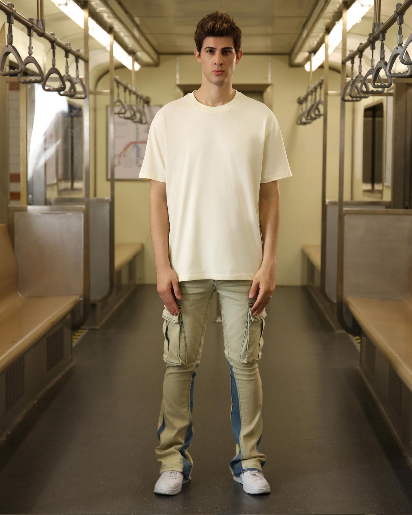 Stylish cream oversized t-shirt paired with cargo jeans in a subway setting
