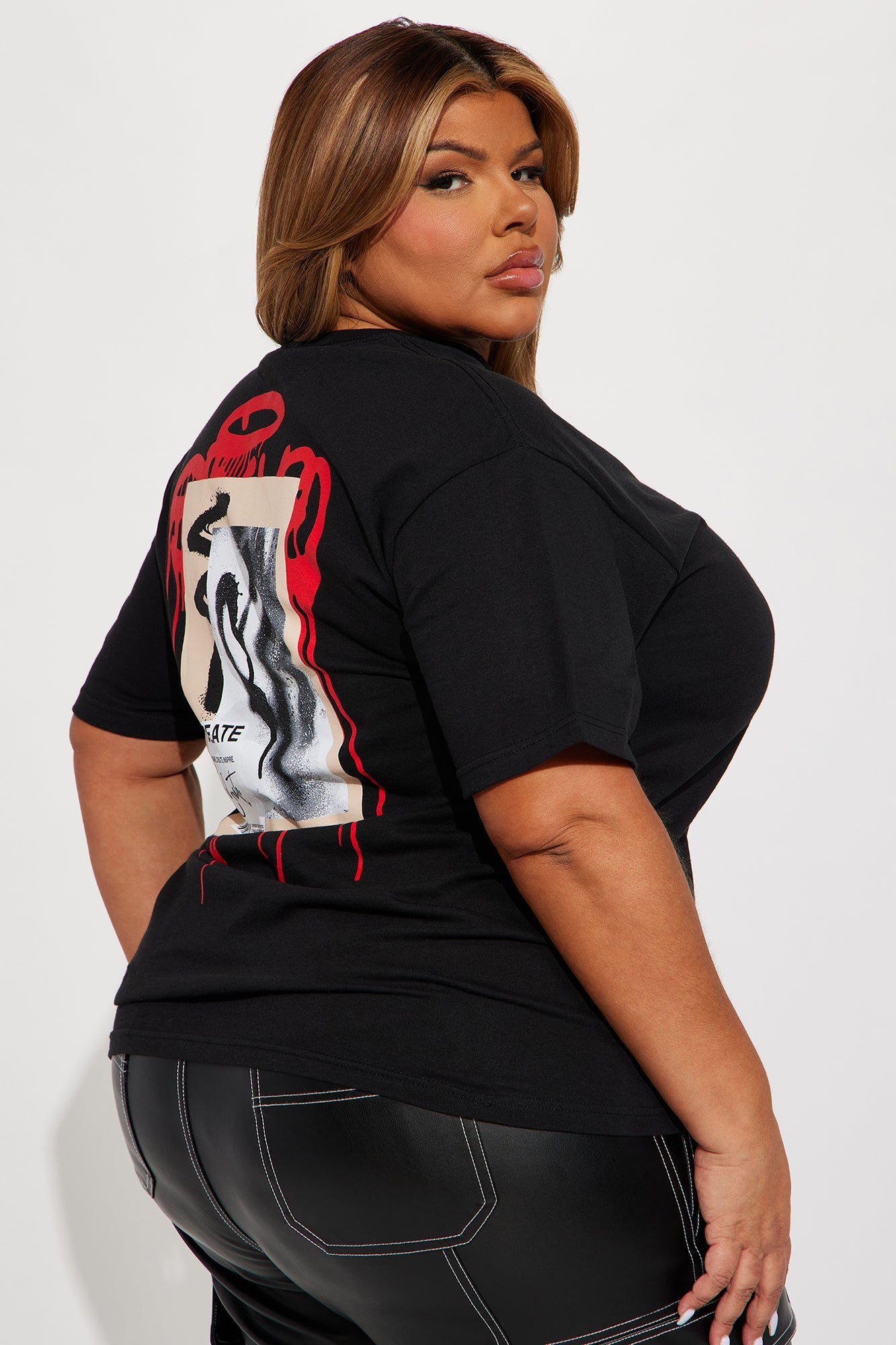Plus size model wearing a black create what you love graphic tee with eye-catching back design