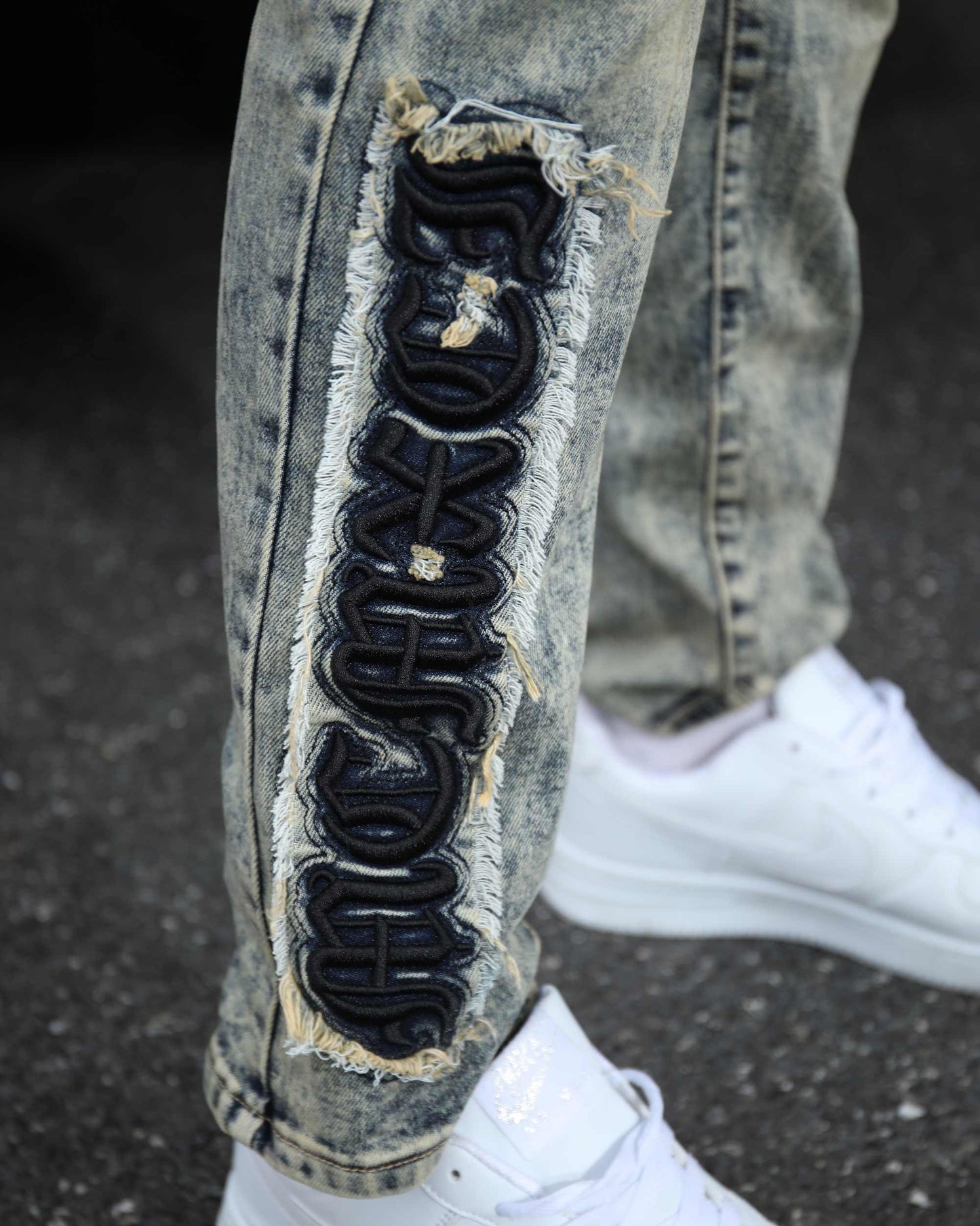 Logeqi dark washed straight leg jeans featuring distressed details and unique patch design