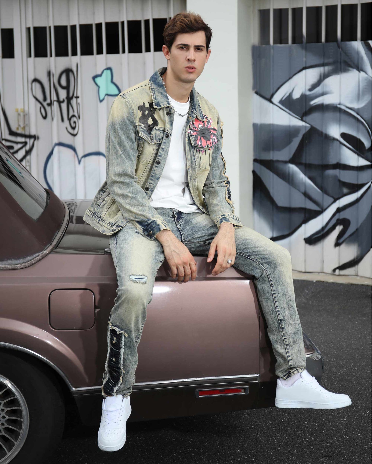 Fashionable model in dark washed straight leg jeans paired with a trendy jacket and white sneakers
