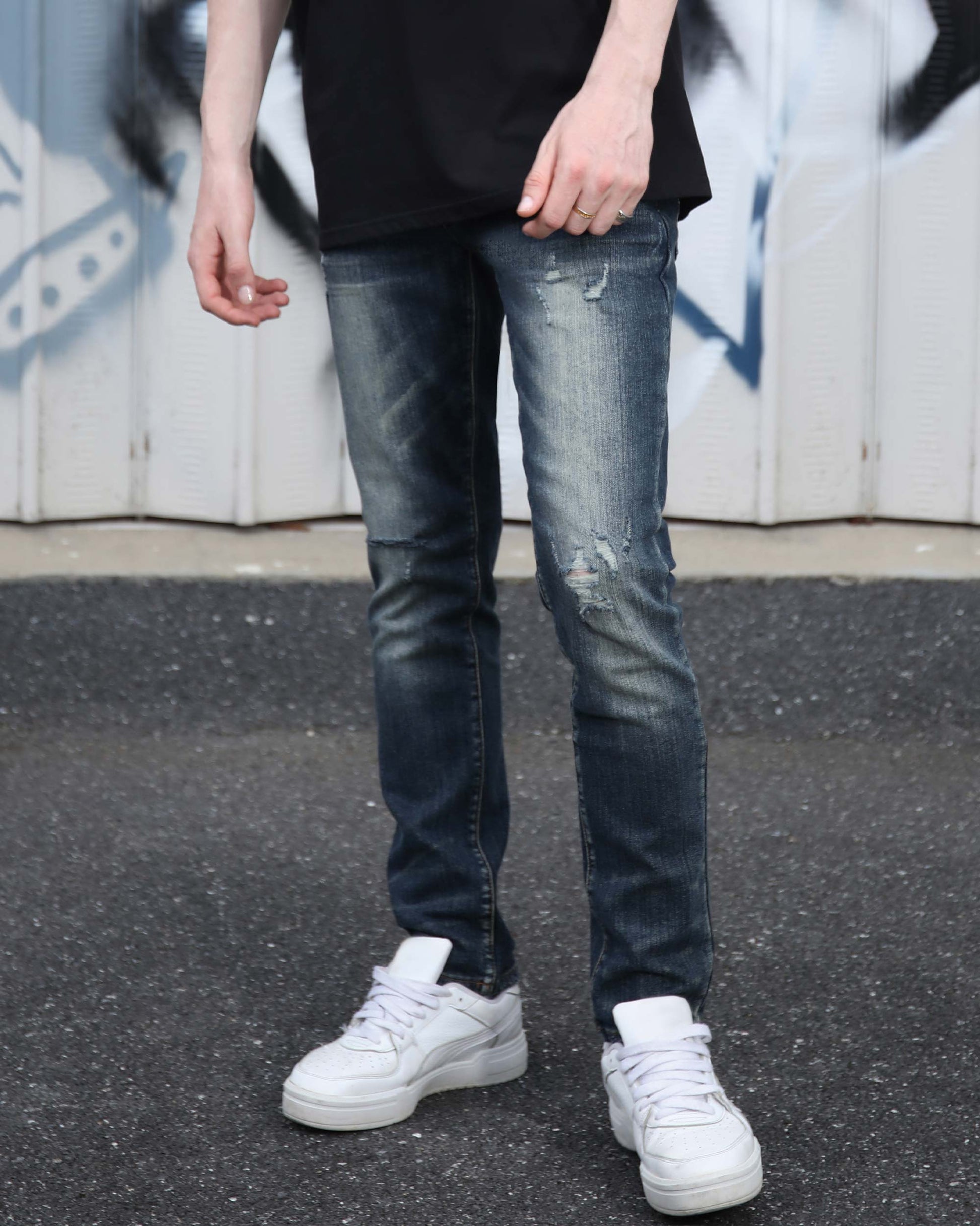 Logeqi slim fit ripped jeans men in dark blue with distressed details worn with white sneakers