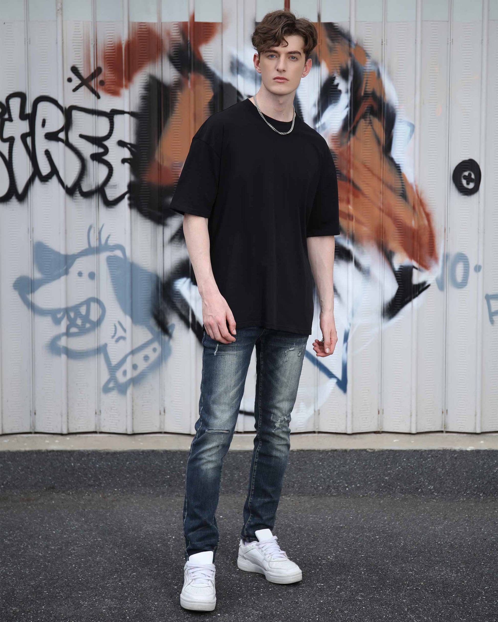Logeqi slim fit ripped jeans men styled with black oversized t-shirt and white sneakers