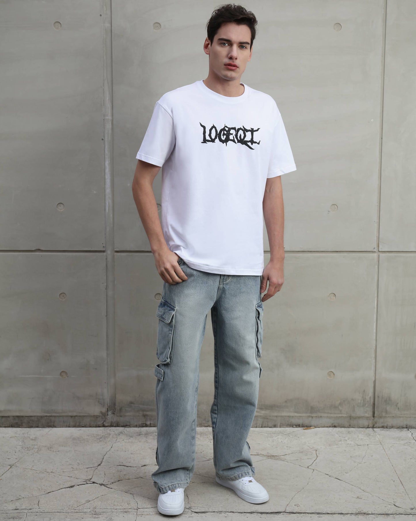 Logeqi distressed blue baggy jeans worn by man with white graphic t-shirt and white sneakers