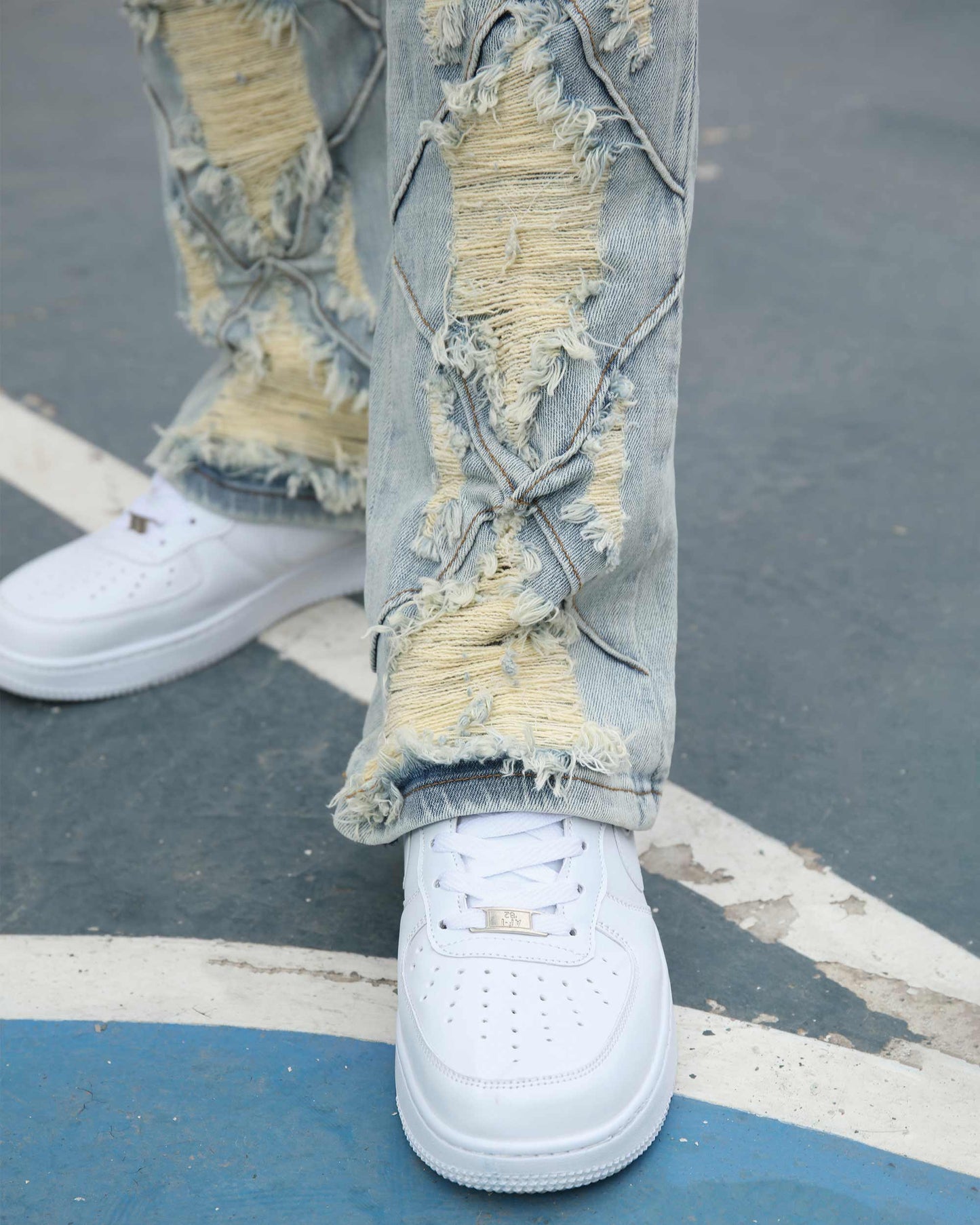 Logeqi distressed blue jeans featuring unique ripped details and paired with white sneakers