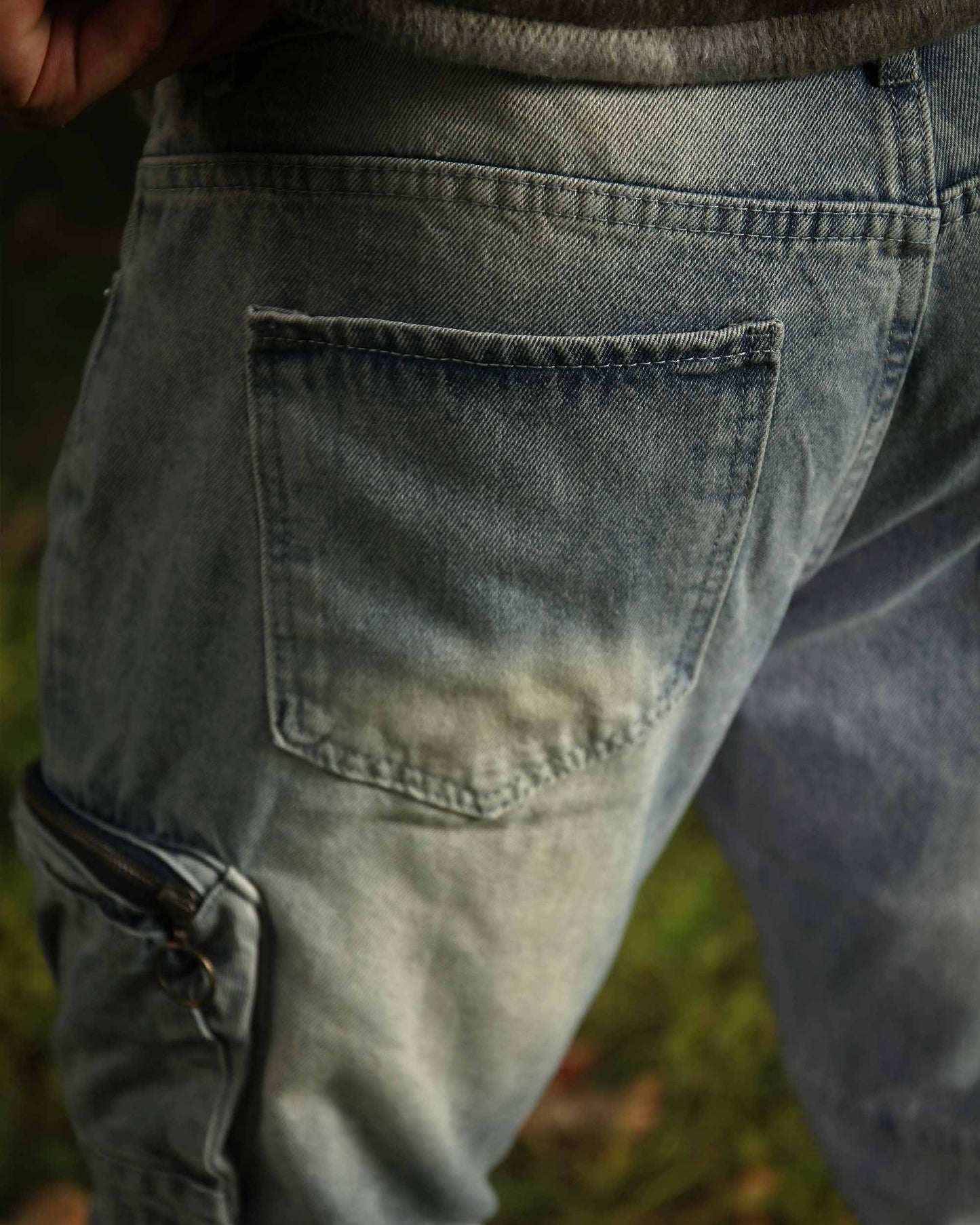 Close-up of Logeqi distressed cargo jeans in faded blue with back pocket and side cargo pocket details