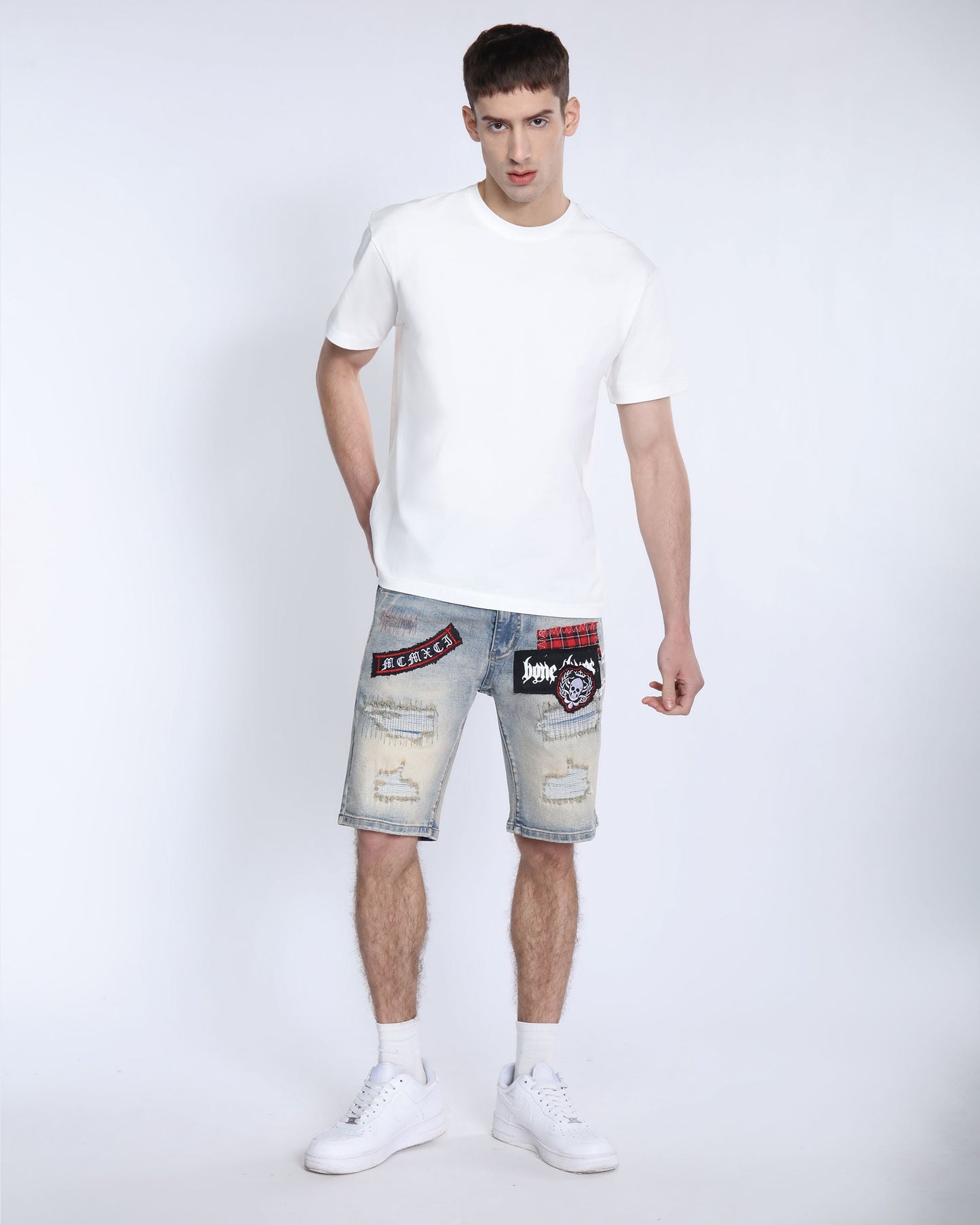 Logeqi distressed denim shorts men with patched design worn with white t-shirt and sneakers