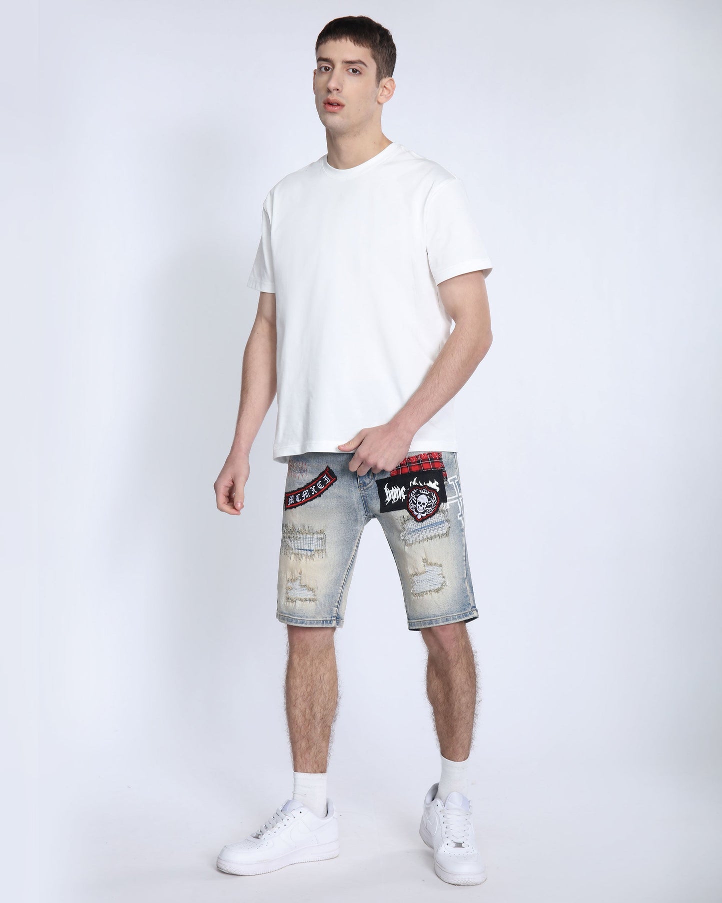 Logeqi distressed denim shorts men with patch designs worn by male model in white t-shirt and sneakers