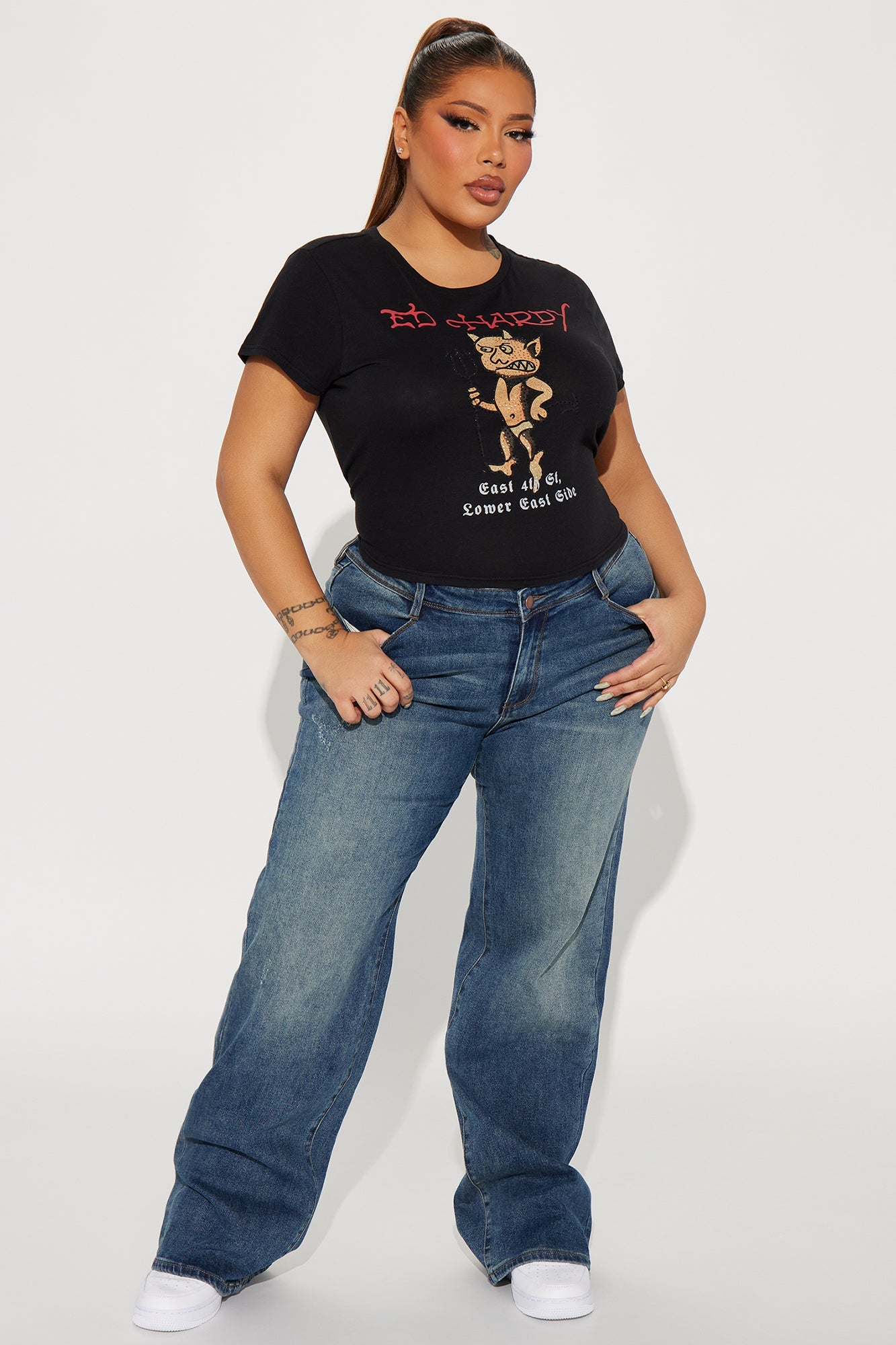 Model wearing Ed Hardy baby devil tee with blue jeans for a trendy casual look